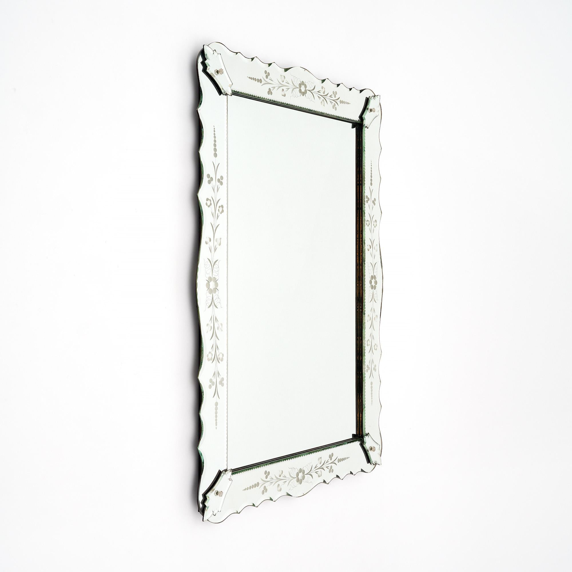 Mirror from the Art Deco period in Venice, Italy. This piece features a frame of scalloped, etched mirror showing a floral pattern throughout. The frame holds a central rectangular mirror in place. This piece is in very nice vintage condition with
