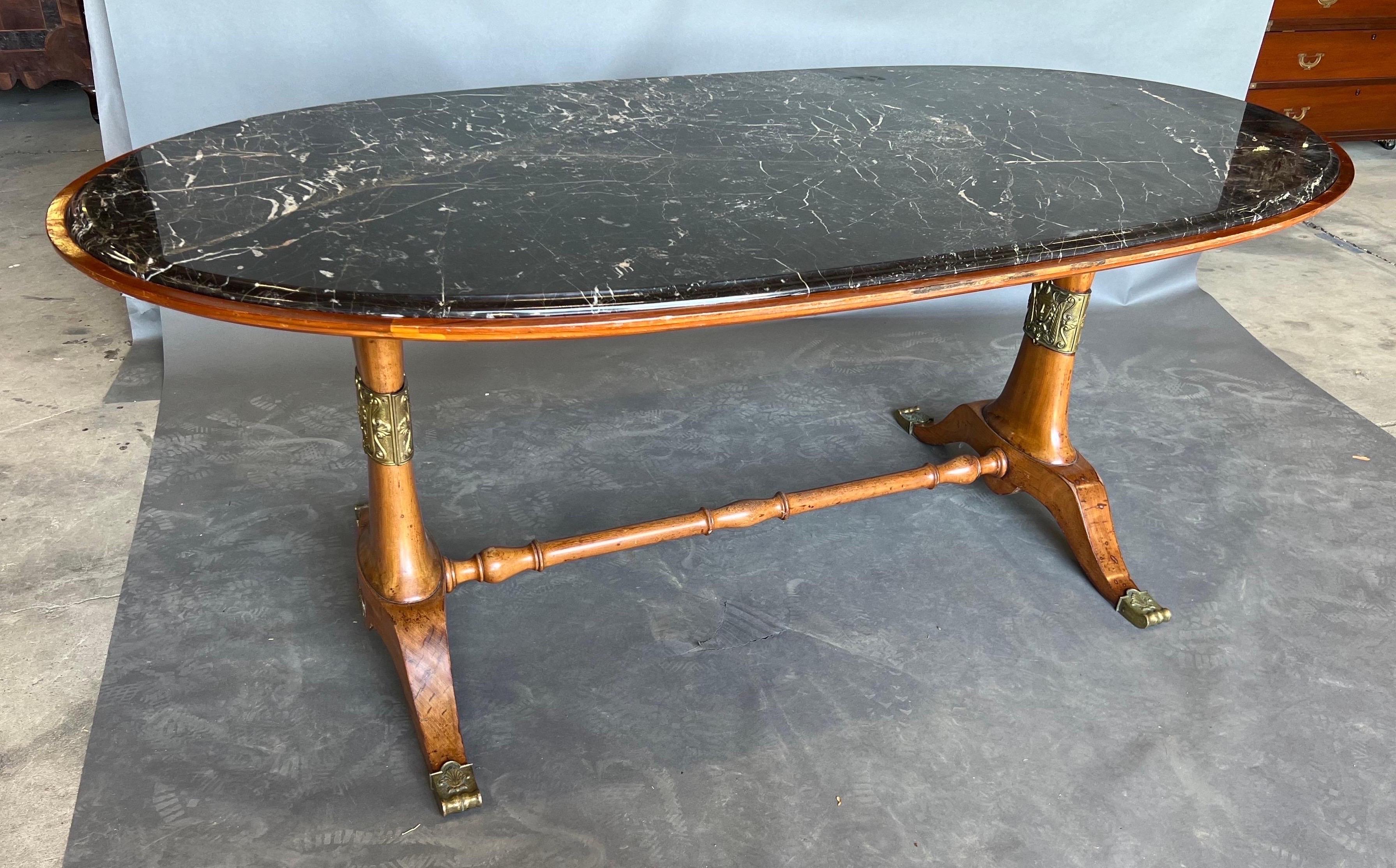 Exceptional art deco period dining or center table. Walnut with bronze tipped feet and decorative appliqués with original black marble top. Would work just as well in a contemporary setting as a room filled with antiques. 

Complimentary shipping