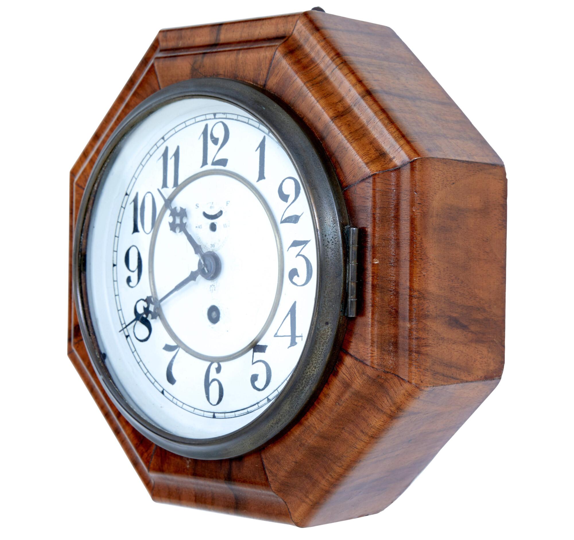 Art Deco period walnut octagonal wall clock by well known German clock maker Junghans, circa 1920. Celebrate the timeless elegance of the Art Deco era with this Walnut wall clock by Junghans, the renowned German clock maker. Crafted circa 1920, this