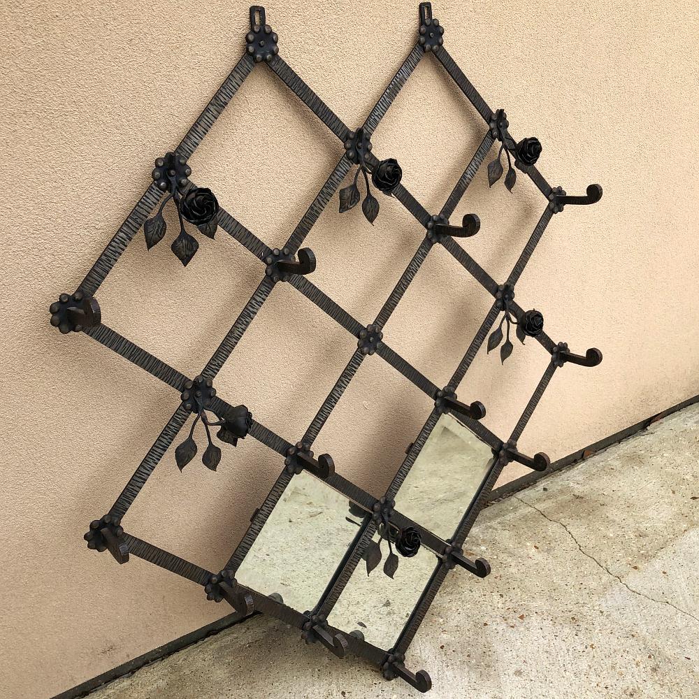 Art Deco period wrought iron hanging hall tree is an intriguing work of the metalsmith's art! A latticework foundation supports rosettes at the junctions, with six floral sprays and thirteen hooks for hats, coats and scarves, it also features three