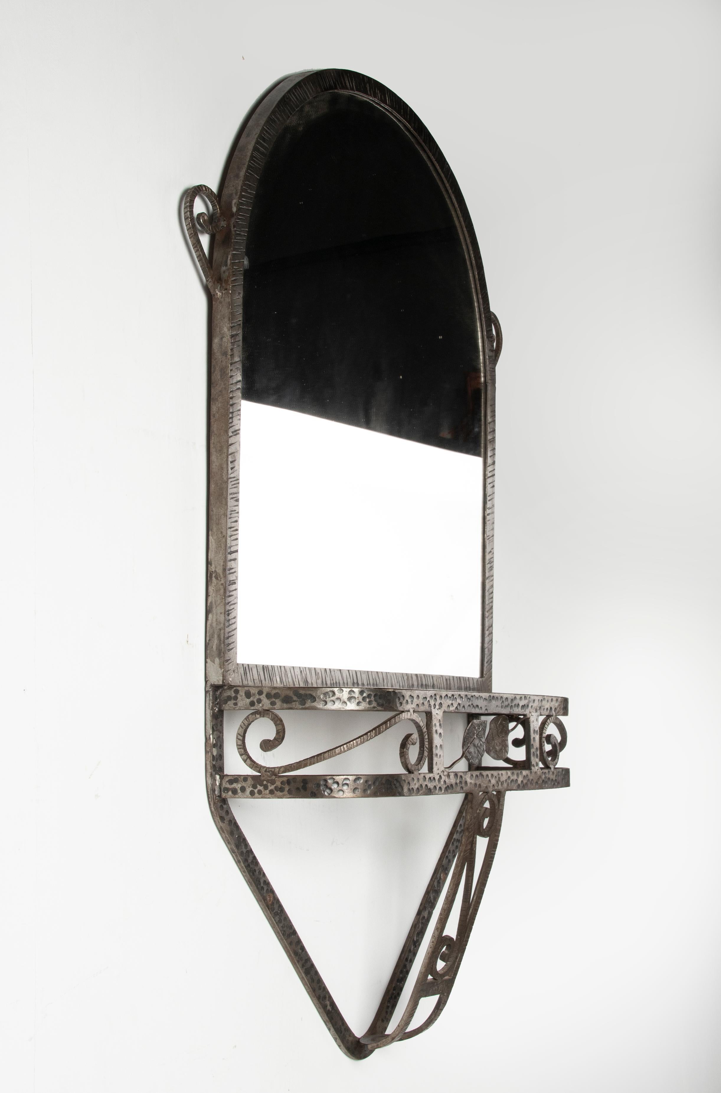 A solid iron hand-forged wall mirror with console table from the Art Deco period. With a red 