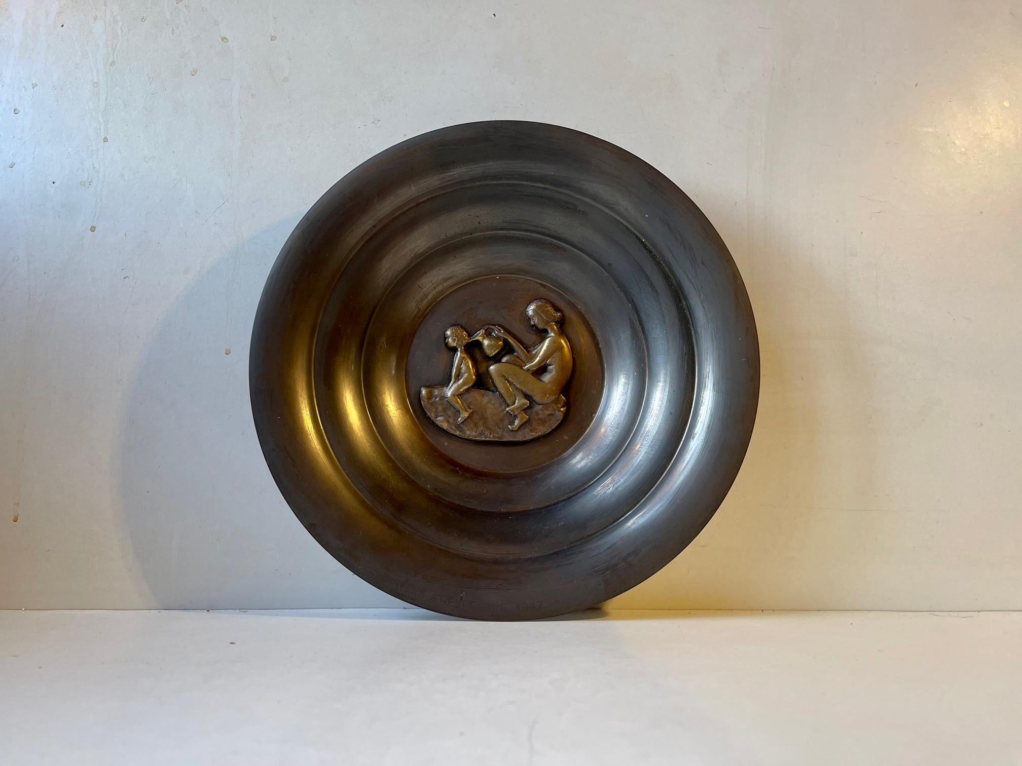 Large Art Deco patinated pewter bowl with a center intimate motif of a mother bathing her child. It is designed by danish N. Dam Ravn and manufactured by Nordisk Malm in Denmark during the 1930s or 40s. The same period Just Andersen took the world