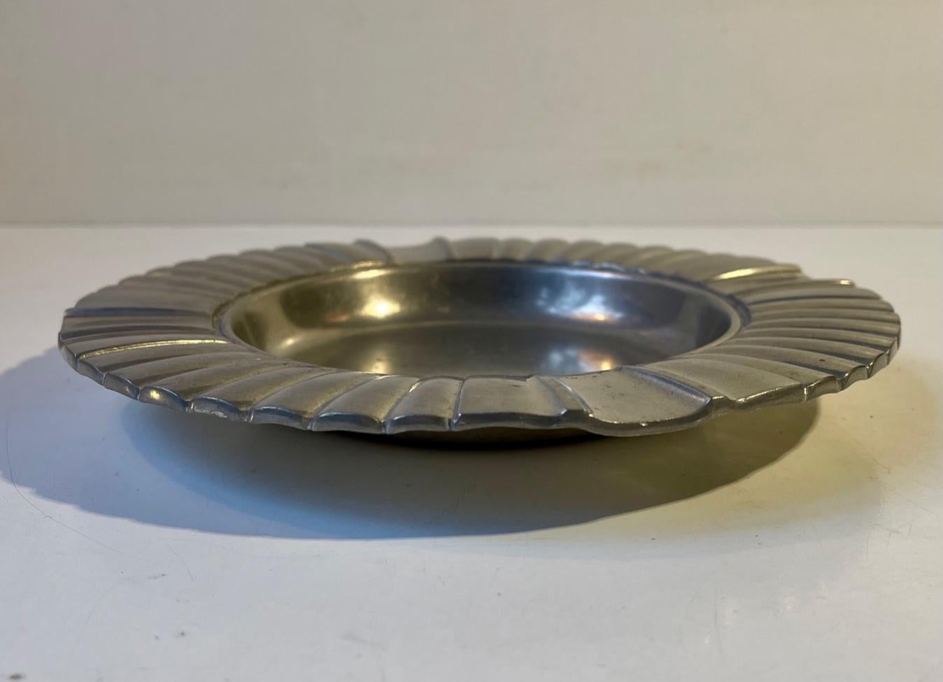 A rare pewter bowl or ashtray with architecturally styled ribbings. Designed and manufactured by Just Andersen in Denmark during the 1930s. Imprinted to its base: Just, Danmark, 2350. Measurements: H: 3 cm, D: 21 cm.