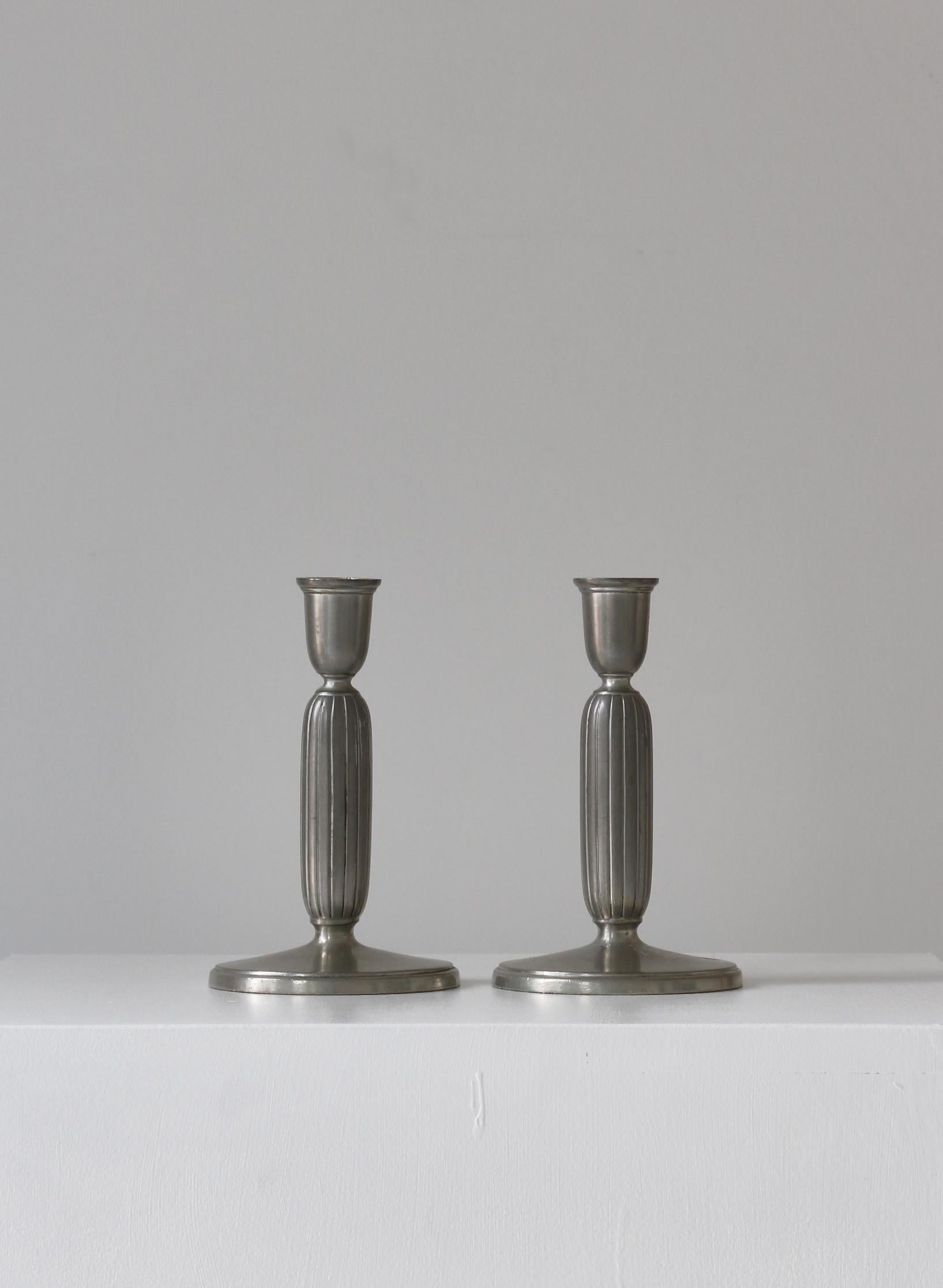 Beautiful set of Art Deco candlesticks in pewter by Just Andersen made at his own workshop in the 1920-30s. Both pieces are stamped with Just Andersen logo and model no. 2574.

Just Andersen was a Danish designer and sculptor who played a