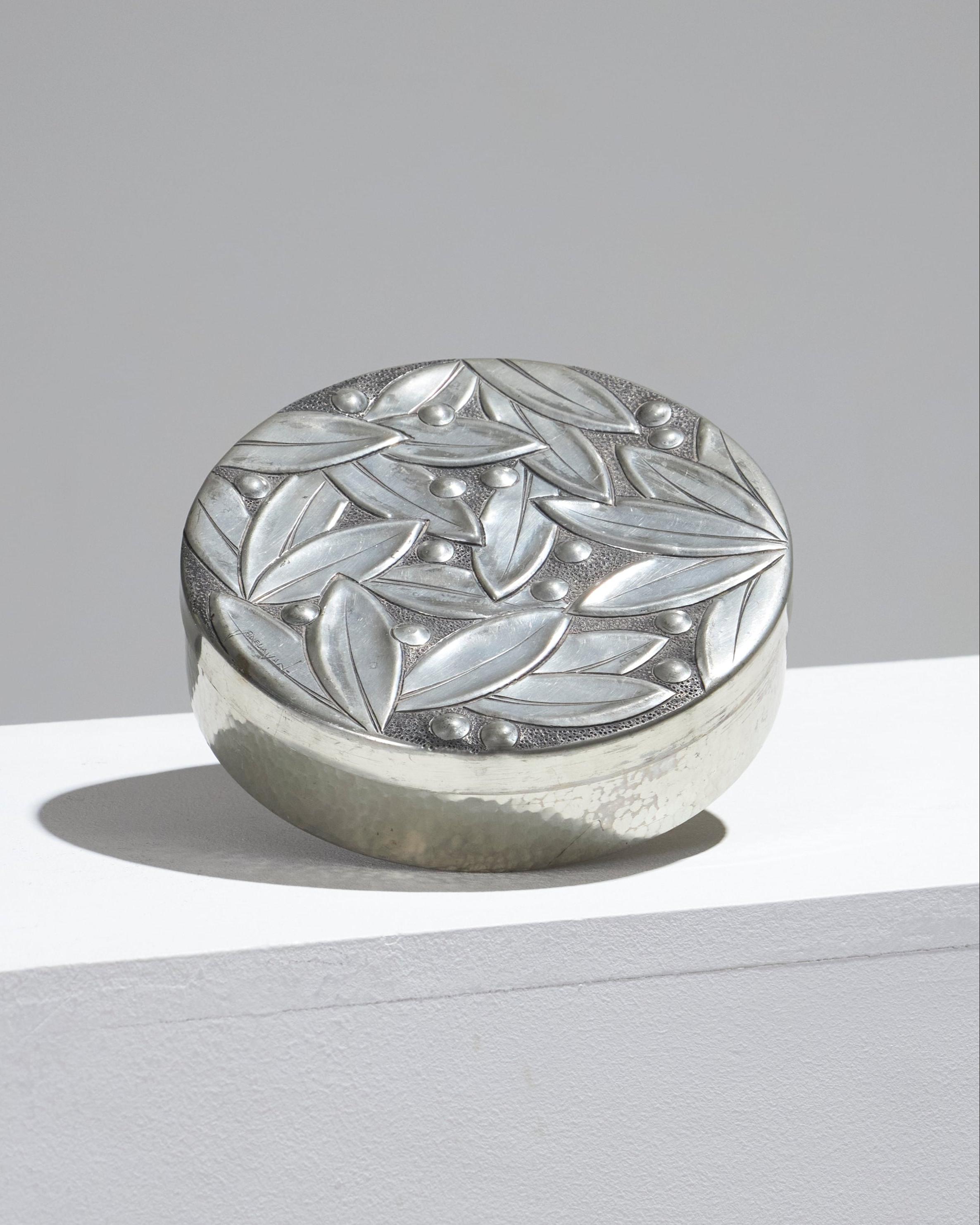 Polished pewter candy box in Art Deco style by René Delavan, made in France in the 1930s. Decorated with leaves and small berries. Marked on the underside and in good condition. Artist's signature engraved within the curve of a leaf.

LP5154
