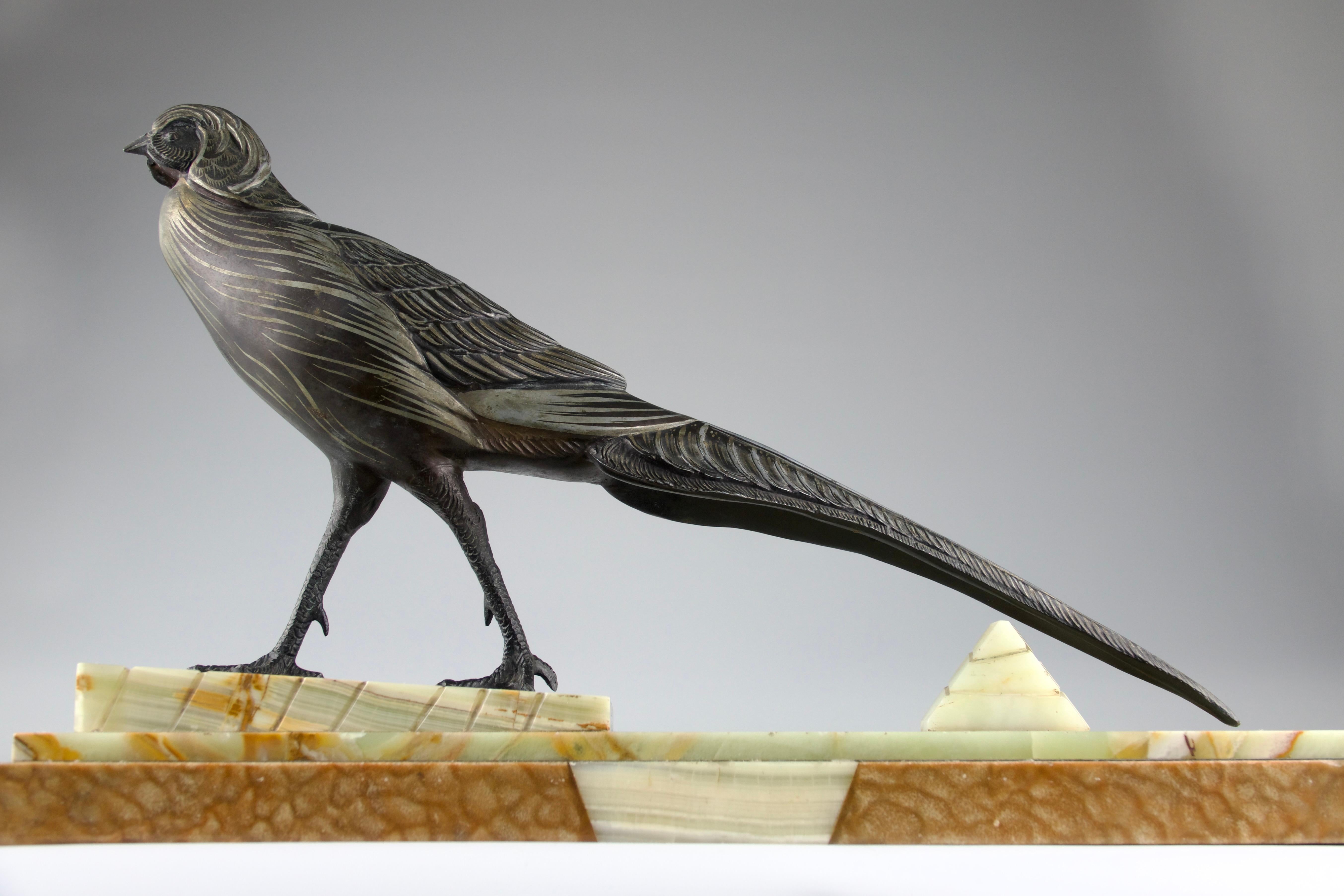 Superb spelter sculpture of a pheasant over a marble base. Intricate detail in the sculpture and patina alternating silver and black to simulate the coat's patterns as well as gouges in the marble simulating the traces left by the pheasant's talons.