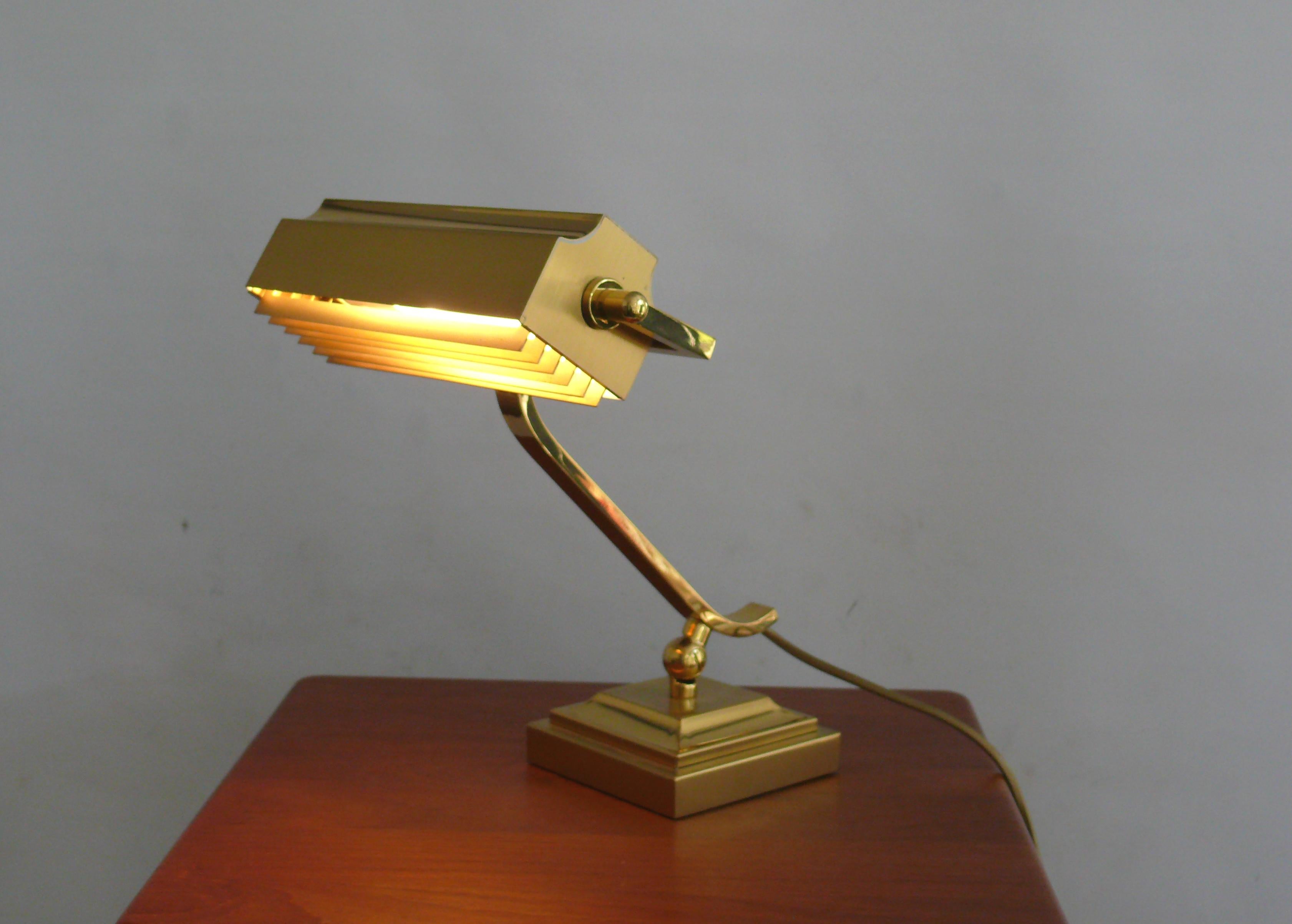Rare, very solid and heavy piano lamp made of brass, circa 1960s - 1970s with removable glare protection. The lamp is made of shiny brass with almost no signs of aging on the brass surface. The umbrella and the arm can be adjusted. The joint can be