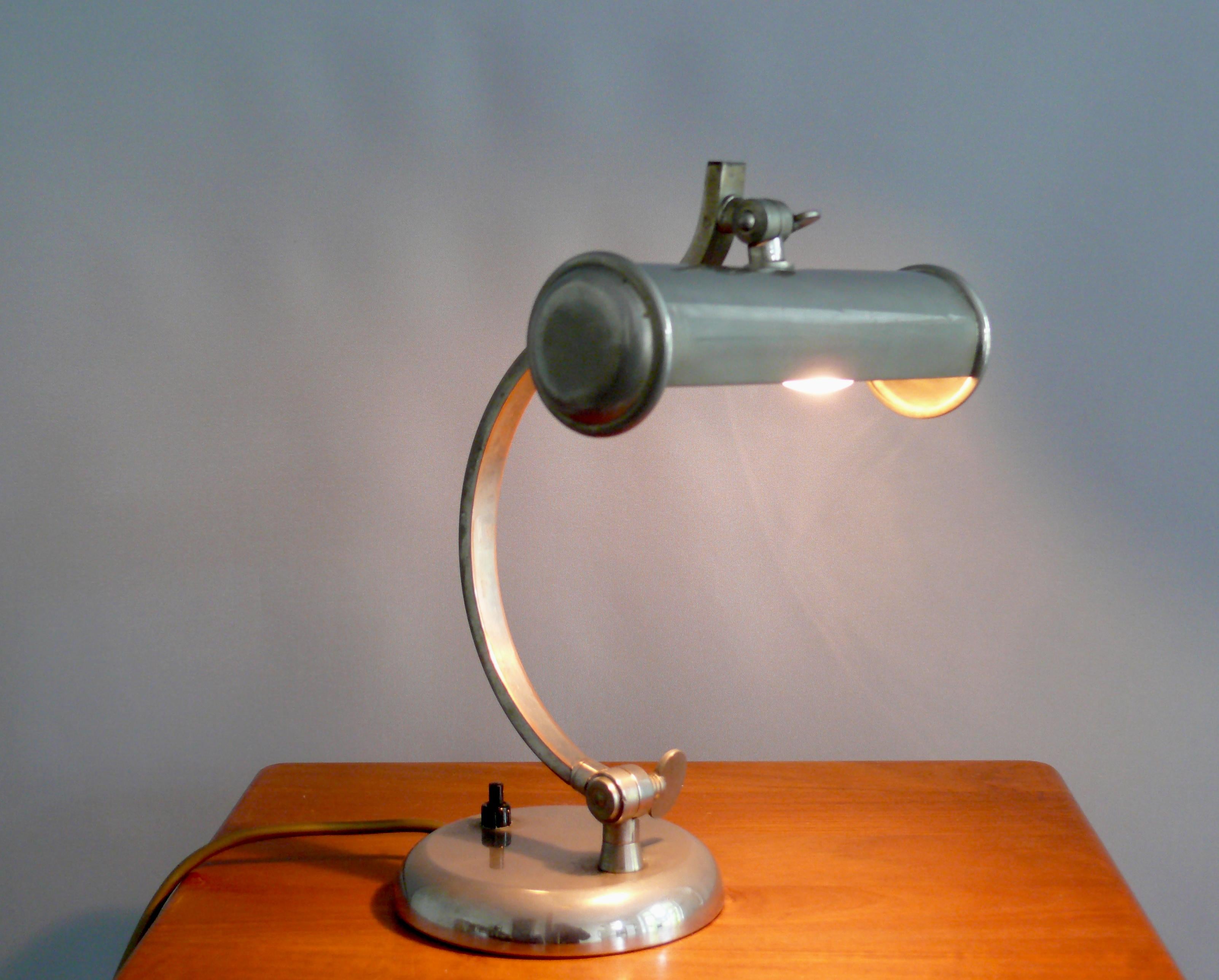 Art Deco Klavierlampe/Tischlampe aus den 1920er-1940er Jahren, komplett verchromt. Aufgrund ihres Designs kann die Leuchte sowohl als Tischleuchte als auch als Klavierleuchte verwendet werden.

Die Lampe ist solide gebaut. Der Schirm und der Arm