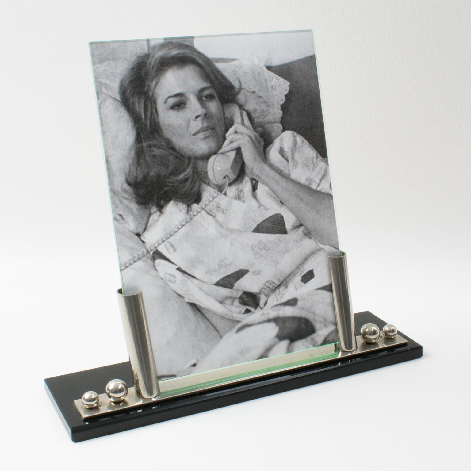 This stylish French Art Deco picture photo frame features a thick black opaline glass plinth complimented with two polished chromed metal holders and two beads accent. The piece is complete with two glass sheets to enclose the photograph. There is
