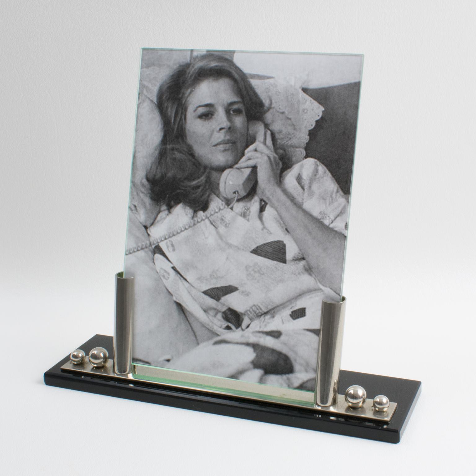 This stylish French Art Deco picture photo frame features a thick black opaline glass plinth complimented with two polished chromed metal holders and two bead accents. The piece is complete with two glass sheets to enclose the photograph. There is