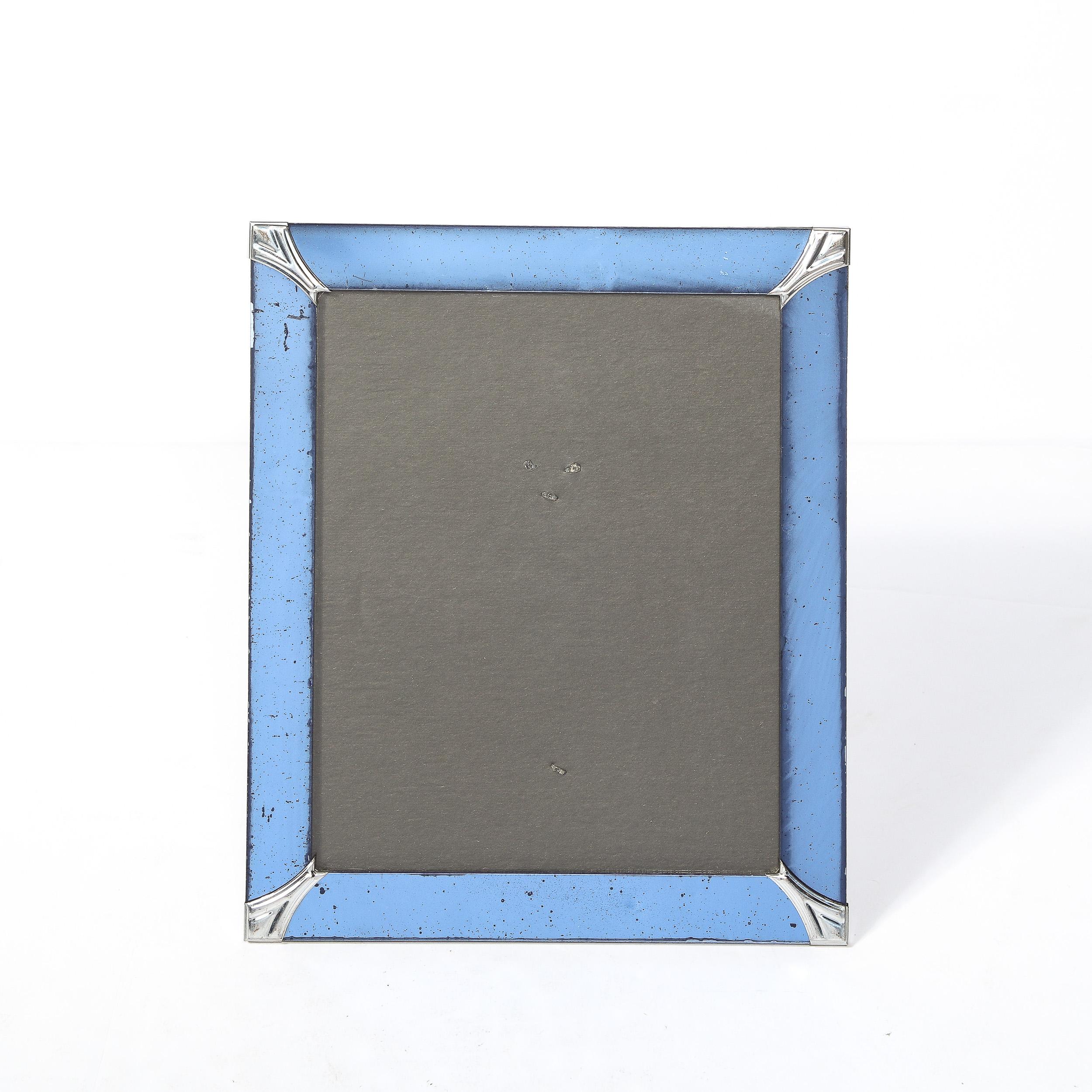 This Art Deco Picture Frame originates from the United States Circa 1935.  It is rendered in gorgeous cobalt blue glass characteristic of the era; beveled detailing on the outside edges, streamlined polished chrome corners expand from the inner