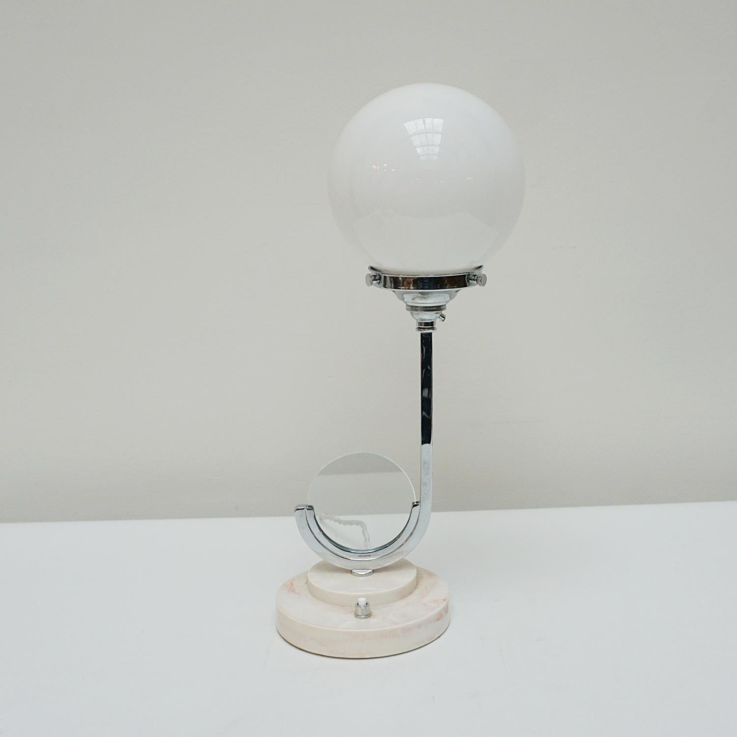 An original Art Deco table lamp. Curved chromed stem with white globe glass shade. Circular stepped marble based with circular glass picture holder at the base.

Dimensions: 42cm W 14cm 

Origin: English

Item Number: J311

All of our lighting is