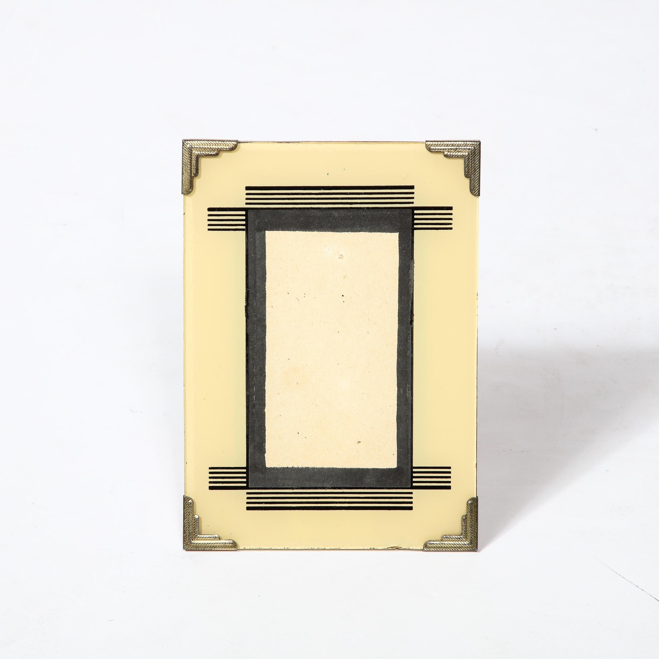 This Art Deco Picture Frame Originates from the United States Circa 1930 and will add a unique accent to any home. It features four streamlined nickel accents on each corner with precise directional hatch-work opening towards a central motif of
