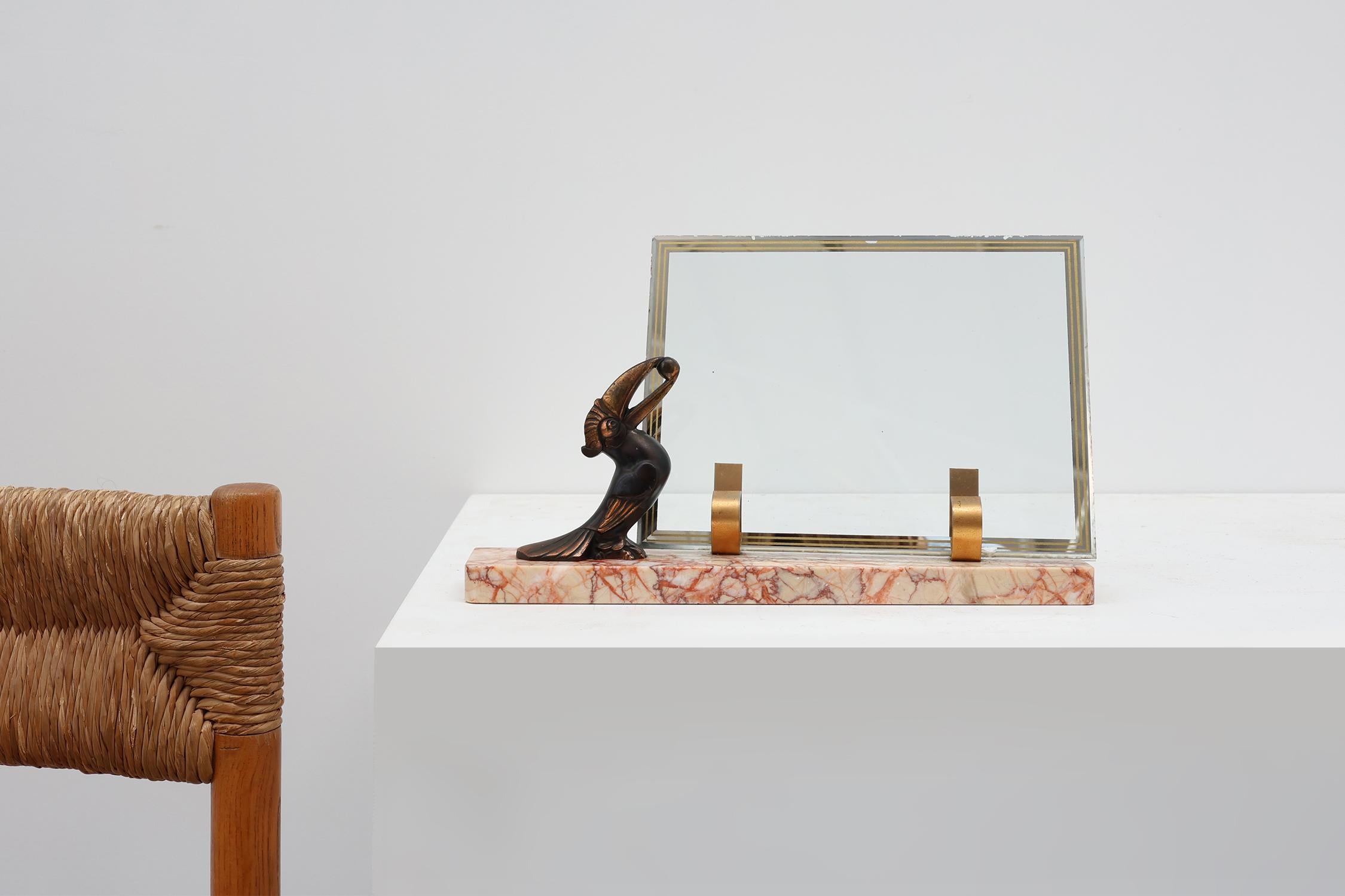 France / 1920 / Picture frame / glass, metal, marble / Art Deco

An exquisite Art Deco picture frame from France, dating to around 1920, featuring a striking sculptural bronzed metal toucan holding a nut, perched on a base of richly veined pink