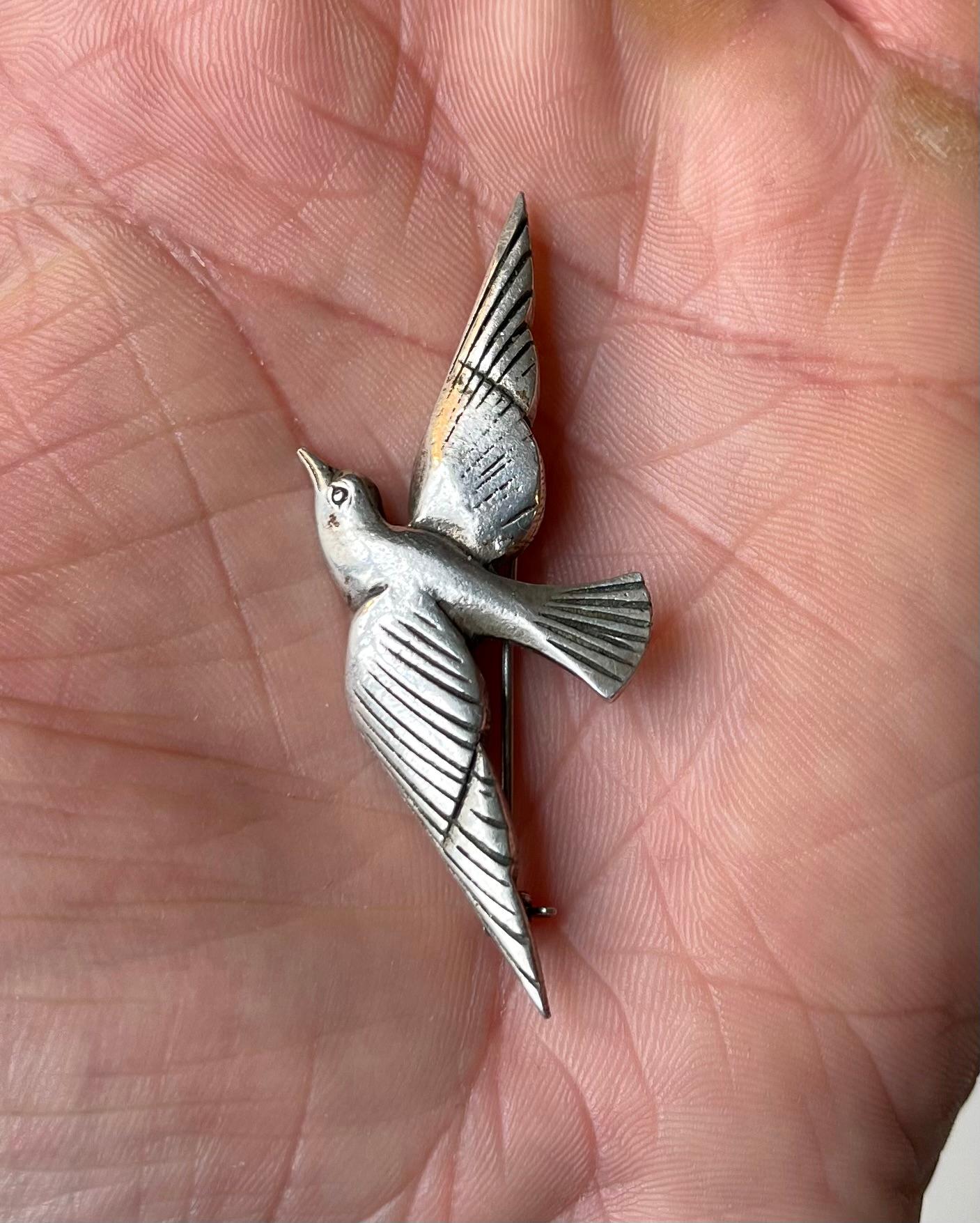 A stylized pin brooch in the shape of a dove. A classic symbol of love and peace. It is executed in 925/1000 sterling silver. Unknown Scandinavian maker circa 1930. Inscribed 925 to its back. Measurements: 6x3x1 cm. The perfect vintage and