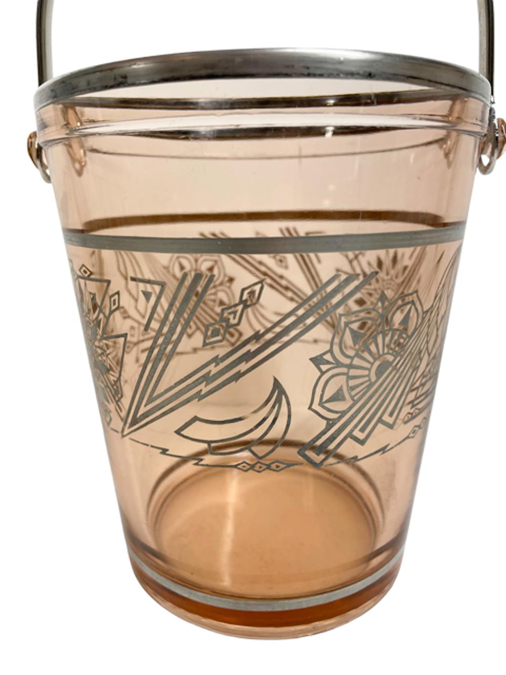 Art Deco pink glass ice bucket with tapered sides decorated with silver overlay stylized floral and geometric motifs of the Jazz Age, a metal bail handle attaches to the rim by means of molded glass lugs.