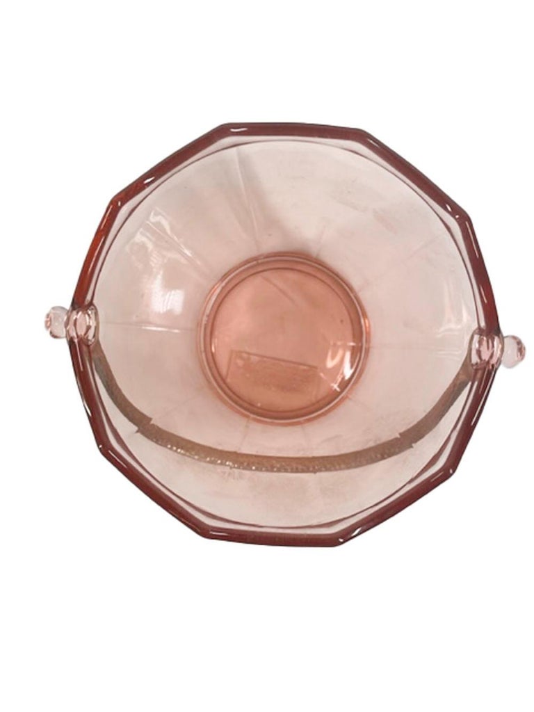 Pale pink glass ice bucket of pail form with hammered handle by Cambridge Glass Company in the 'Elegant Glass' pattern. The bucket with a scalloped rim above tapered sides divided into ten panels. Marked with a 'C' within a triangle to the underside.
