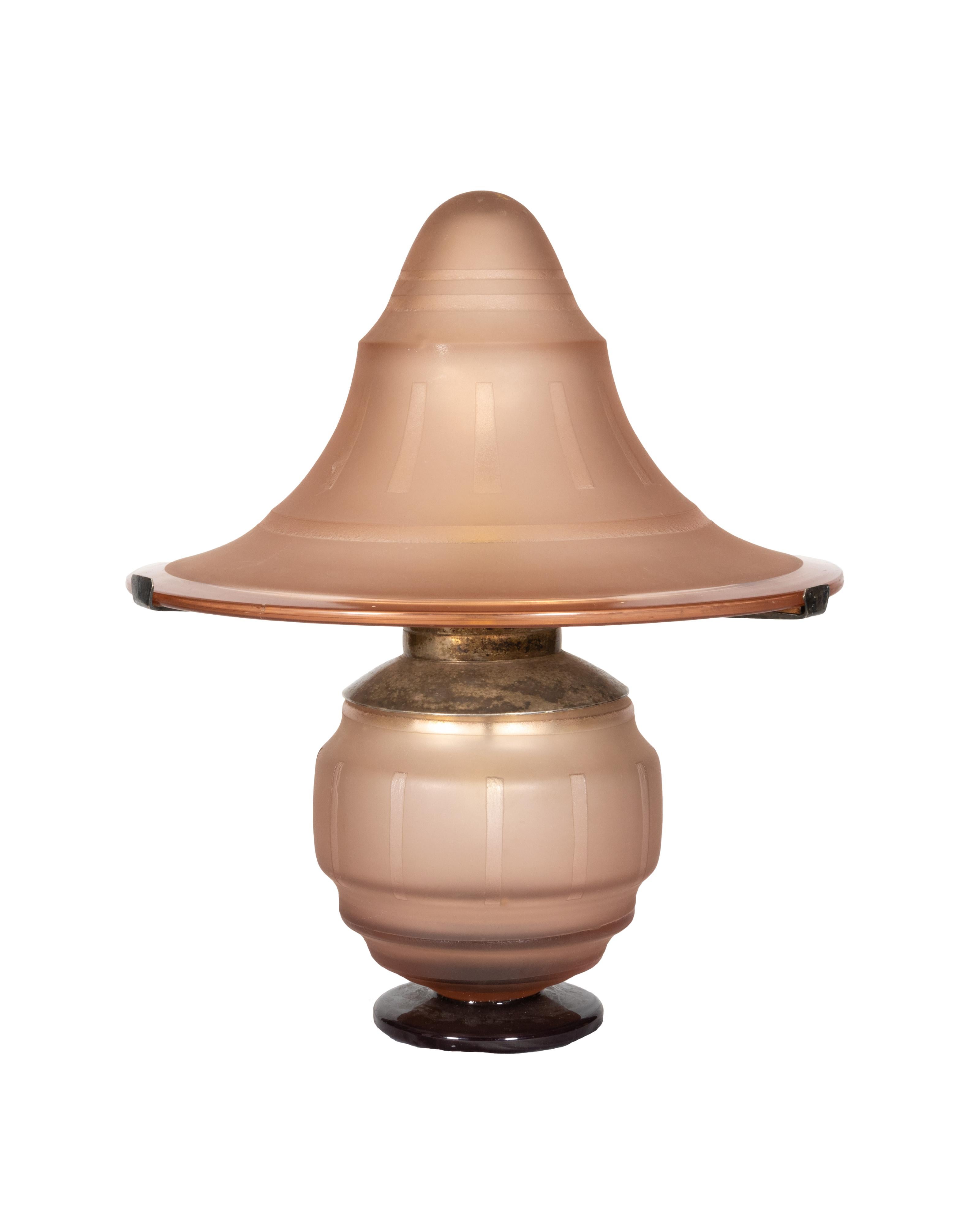 Una rara lampada da tavolo francese a forma di fungo degli anni '30, realizzata in vetro smerigliato rosa con un collare in metallo.

Il vetro smerigliato rosa tenue si illumina di luce calda quando viene acceso, creando un'atmosfera rilassante,