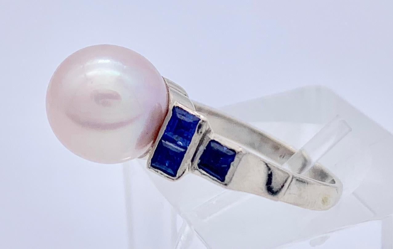 Dieser stilvolle Art-Déco-Ring besteht aus zwei mit Saphiren besetzten Stufen, die zu einer schönen, intensiv rosafarbenen Zuchtperle führen. Die Perle und die sechs quadratisch geschliffenen Saphire sind in 14 Karat Weißgold gefasst.


Ring Größe: