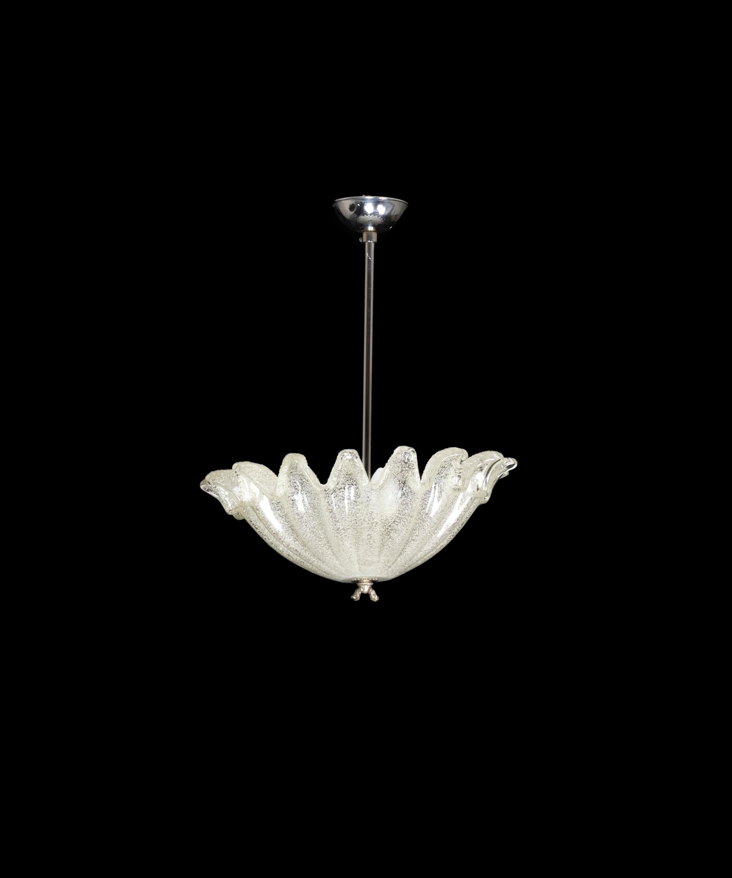 Questa lampada a sospensione cromata Art Déco vanta un paralume traslucido in vetro di Murano sormontato da una cupola di foglie disegnate.

La luce centrale pende graziosamente da un elegante stelo cromato, che ne esalta il fascino