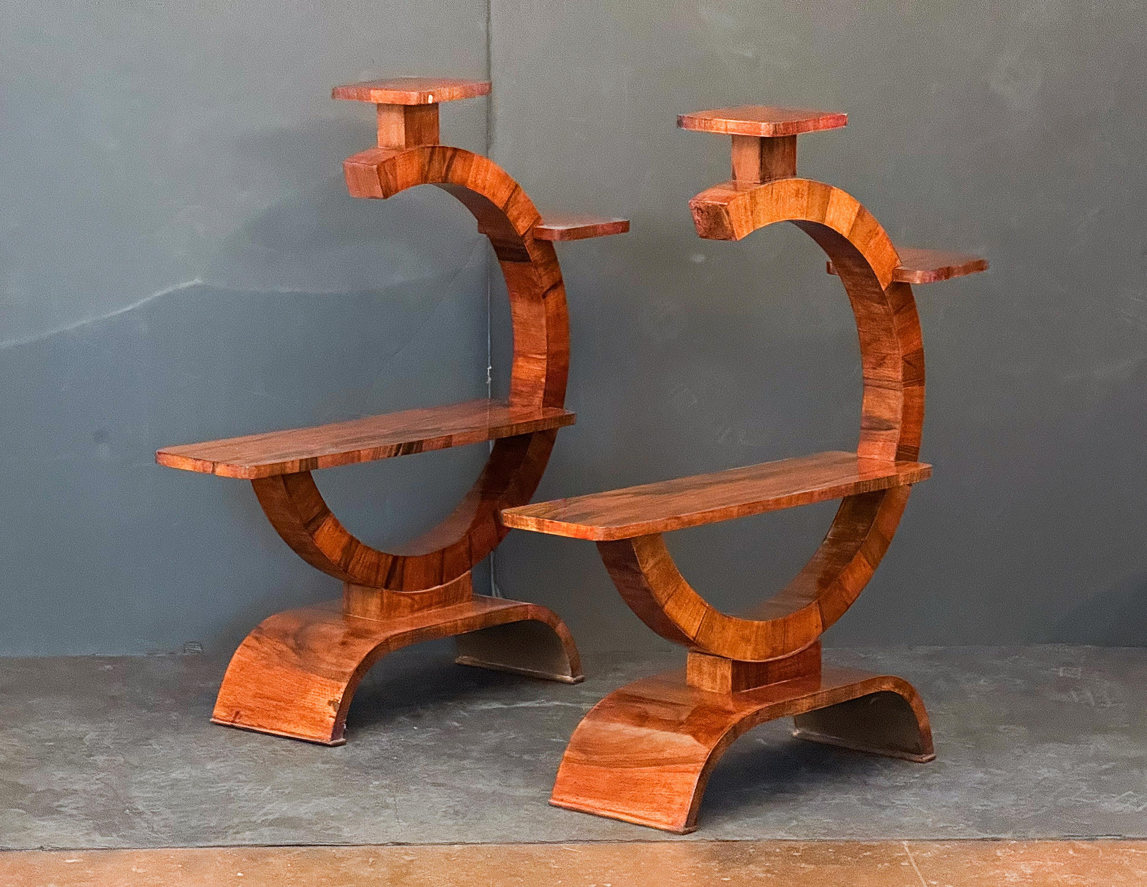 Un set di due piantane italiane di epoca Art Déco - ogni piantana presenta belle impiallacciature di noce, con tre ripiani disposti in un design modernista con stili Art Déco, su una base ad arco.

H. H.: 38,25 pollici 
W: 36 in 
D: 9,38