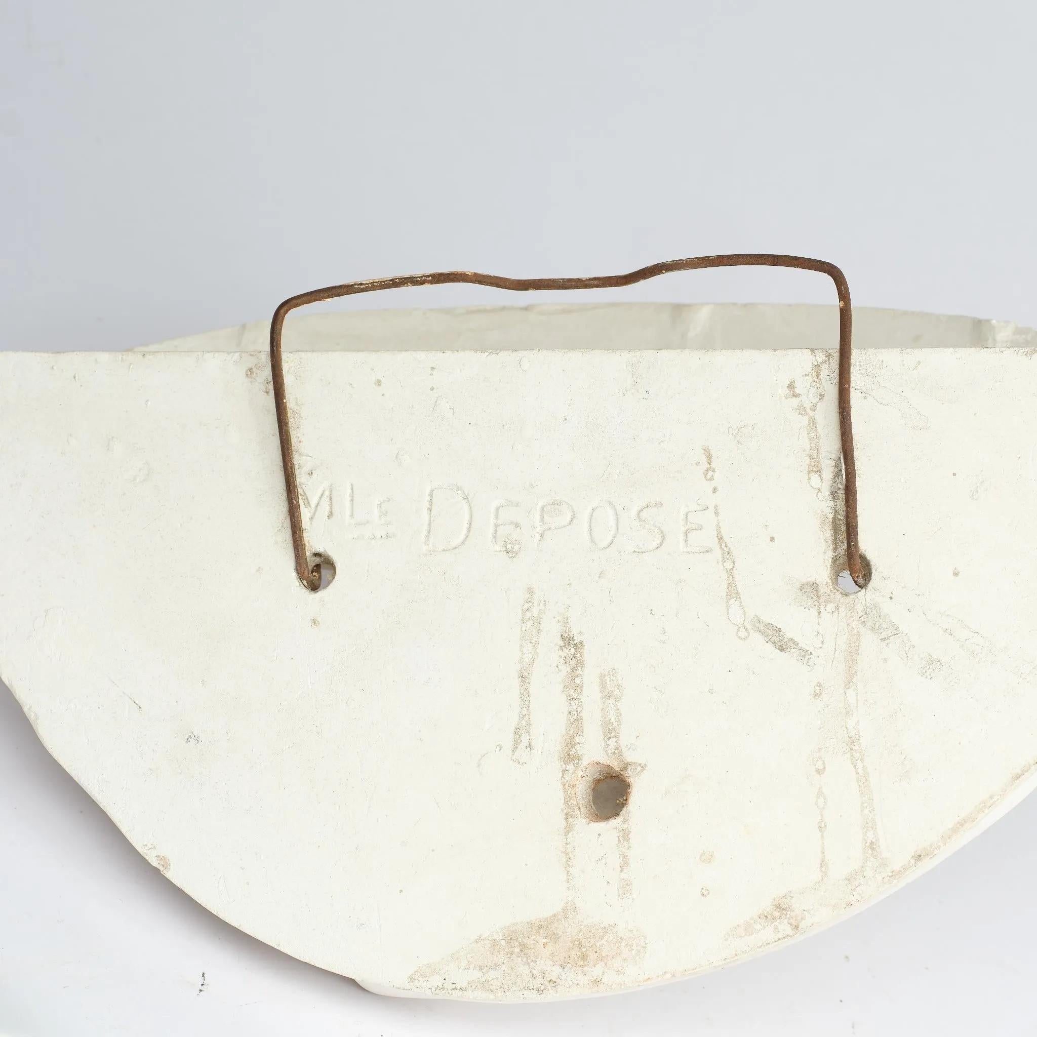Europeo applique in gesso art déco decorata con un nano che regge dei drappi, circa 1930 in vendita