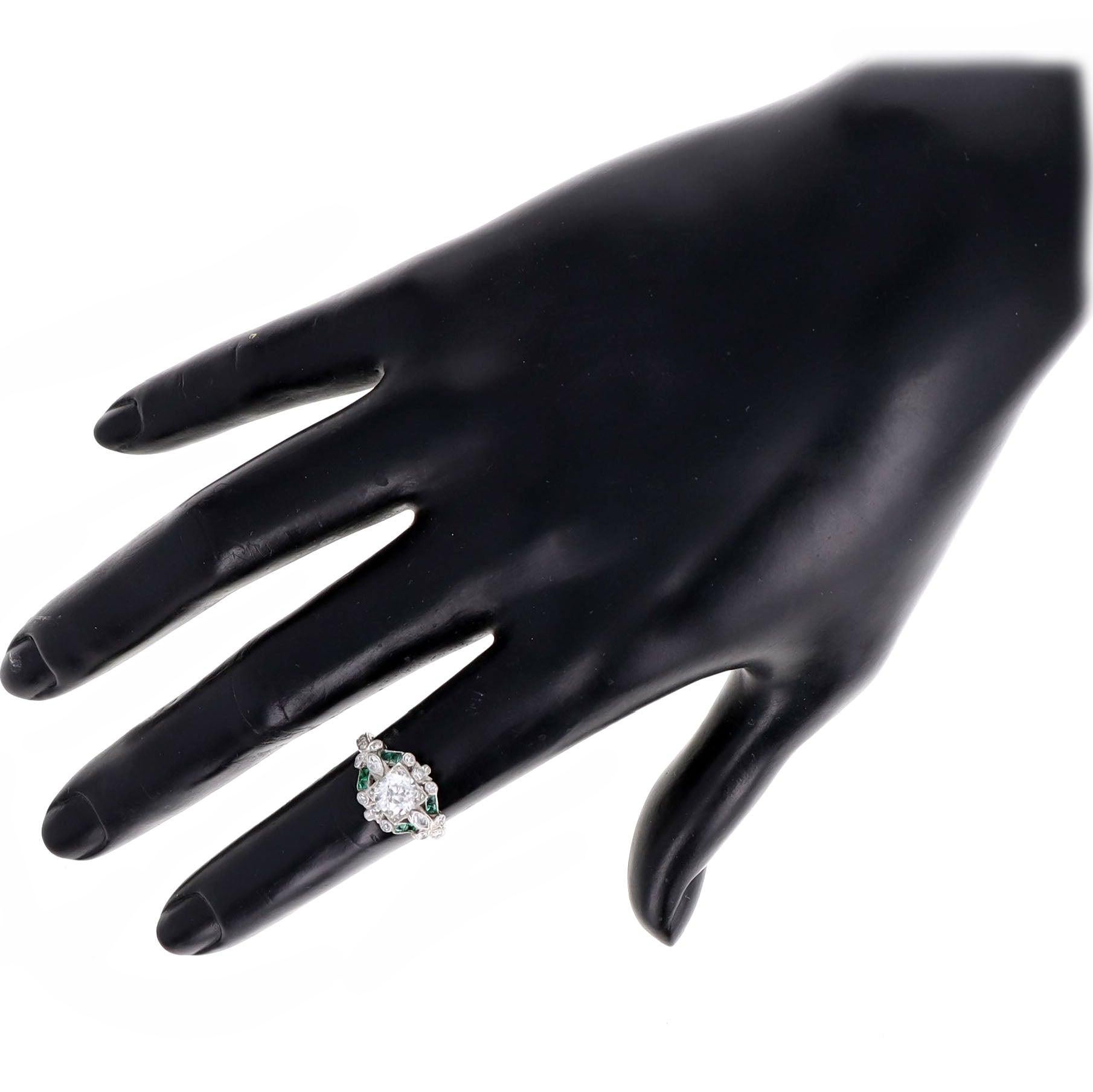 Epoche: Art Deco

Zusammensetzung: Platin

Primärer Stein: Diamant im alten europäischen Schliff

Karat Gewicht: Ungefähr 0,90 Karat

Farbe/Klarheit: H / VS1

Akzent-Stein: Acht natürliche Smaragde im französischen Schliff

Karat-Gewicht: Ungefähr