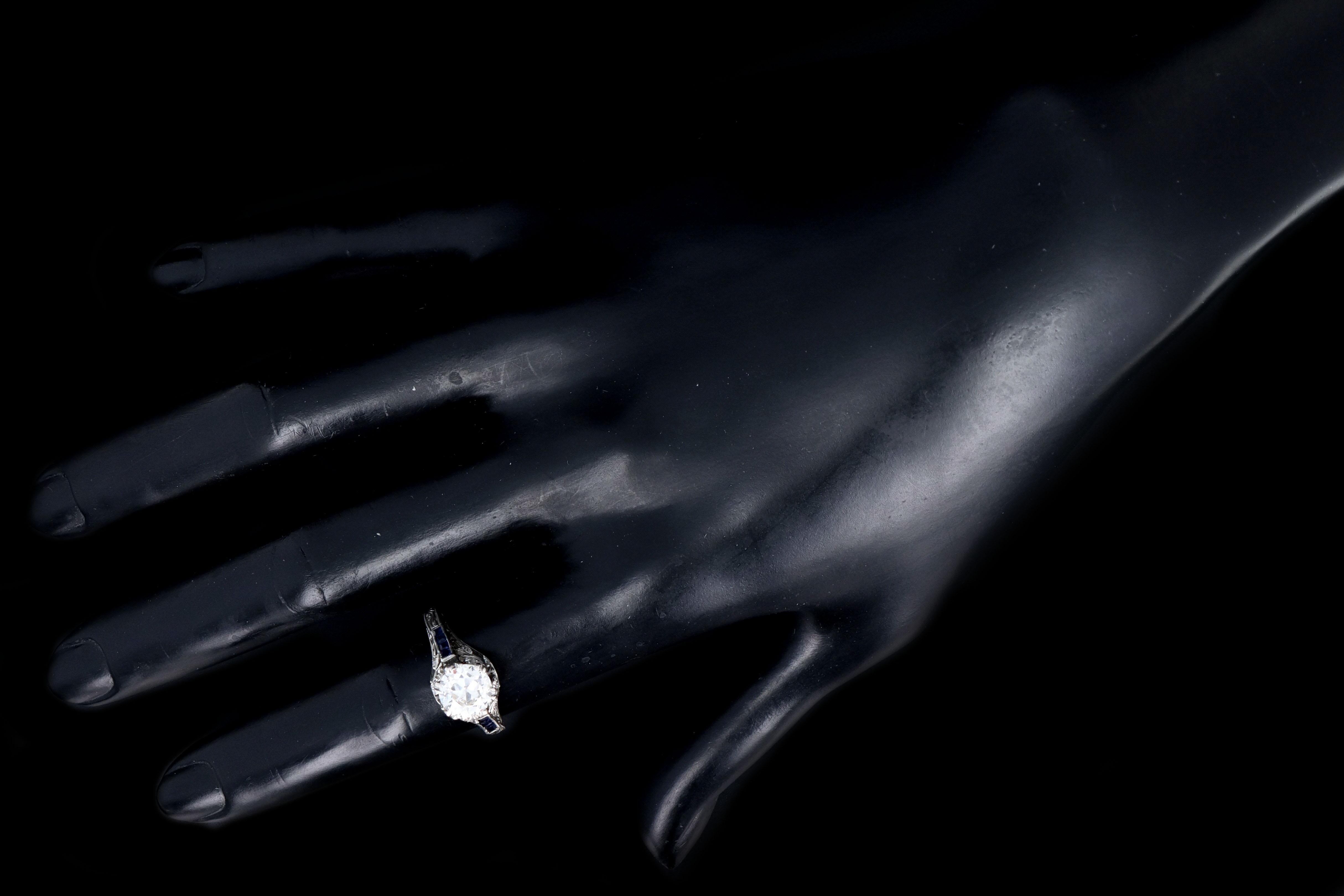 Epoche: Art Deco

Zusammensetzung: Platin 

Primärer Stein: Diamant im alten europäischen Schliff

Primärstein Karat: Ungefähr 1,25 Karat

Farbe / Reinheit: H / SI1

Akzent-Stein: (8) Synthetische Saphire im französischen Schliff

Karat Gewicht: