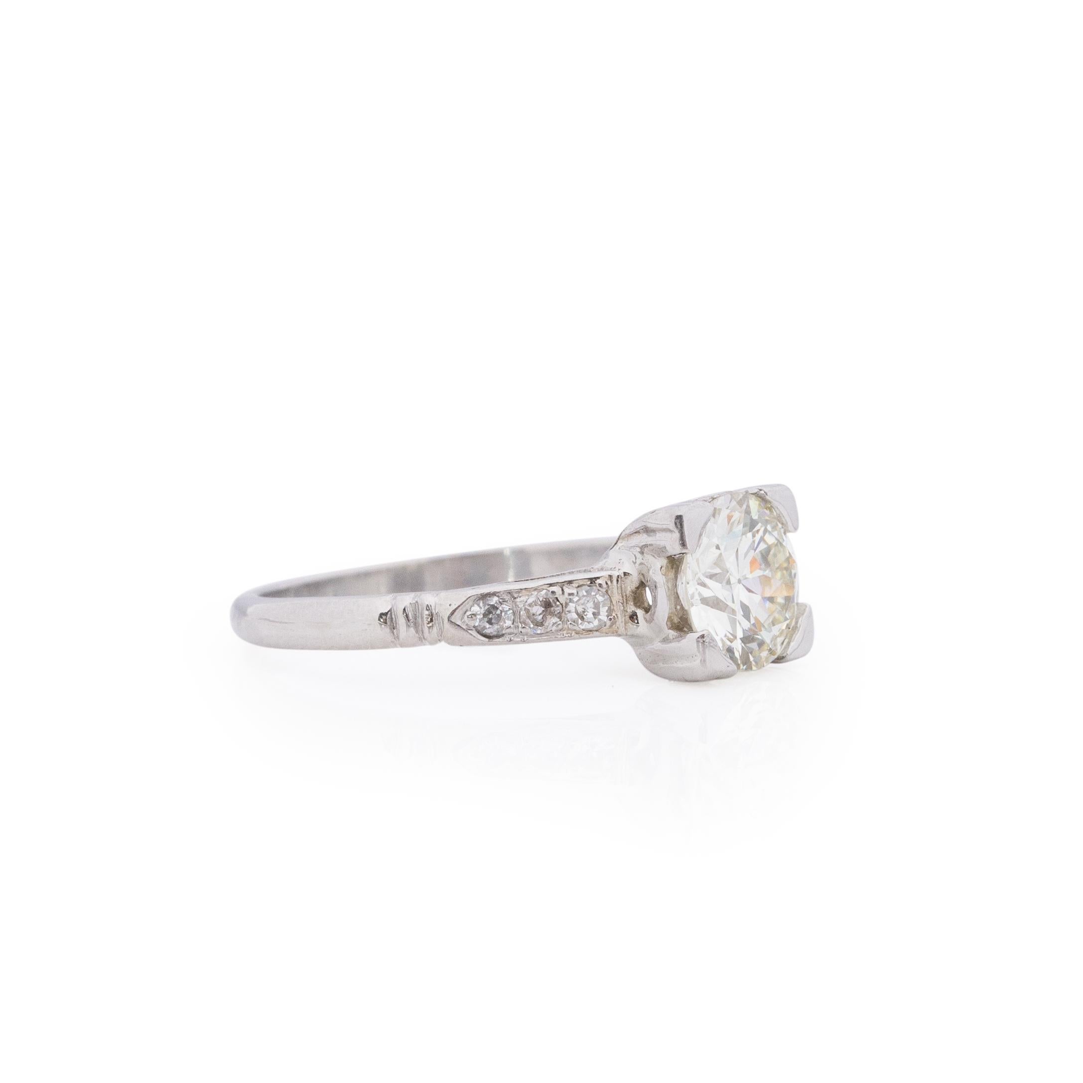 This art deco solitaire ring is a beauty. Crafted in platinum, the simple and classic cathedral shanks hold six bright single cut accent diamonds. Leading to the center diamond set in a illusion head. This 1.25Ct old European cut diamond is bright