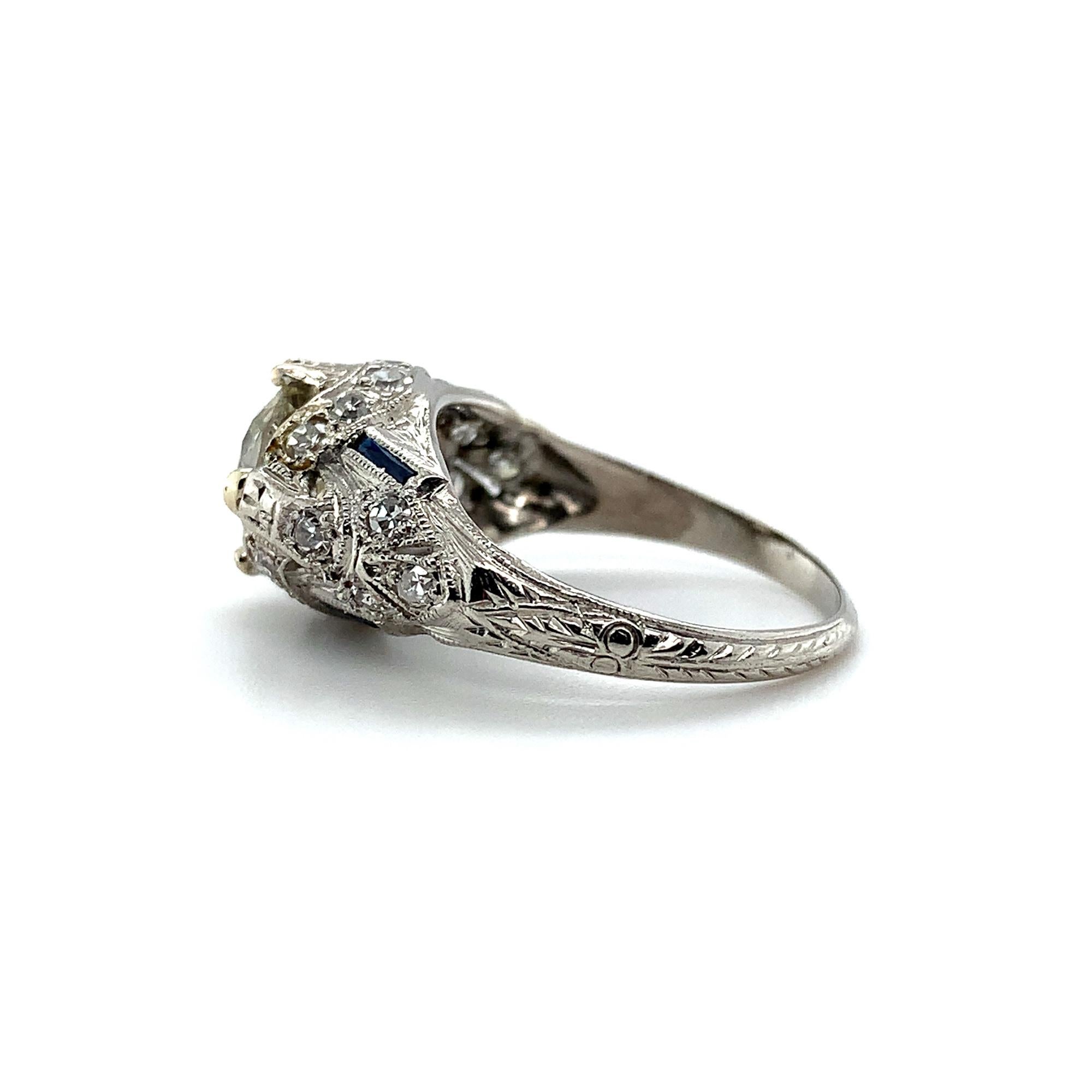 Art Deco platinum filigree ring featuring an European cut diamond weighing 1.31cts with GIA report. GIA report #2221447074 states Q-R color and I1 clarity. The diamond measures 6.86mm x 6.98mm x 4.23mm. There are 4 specialty caliber French cut long