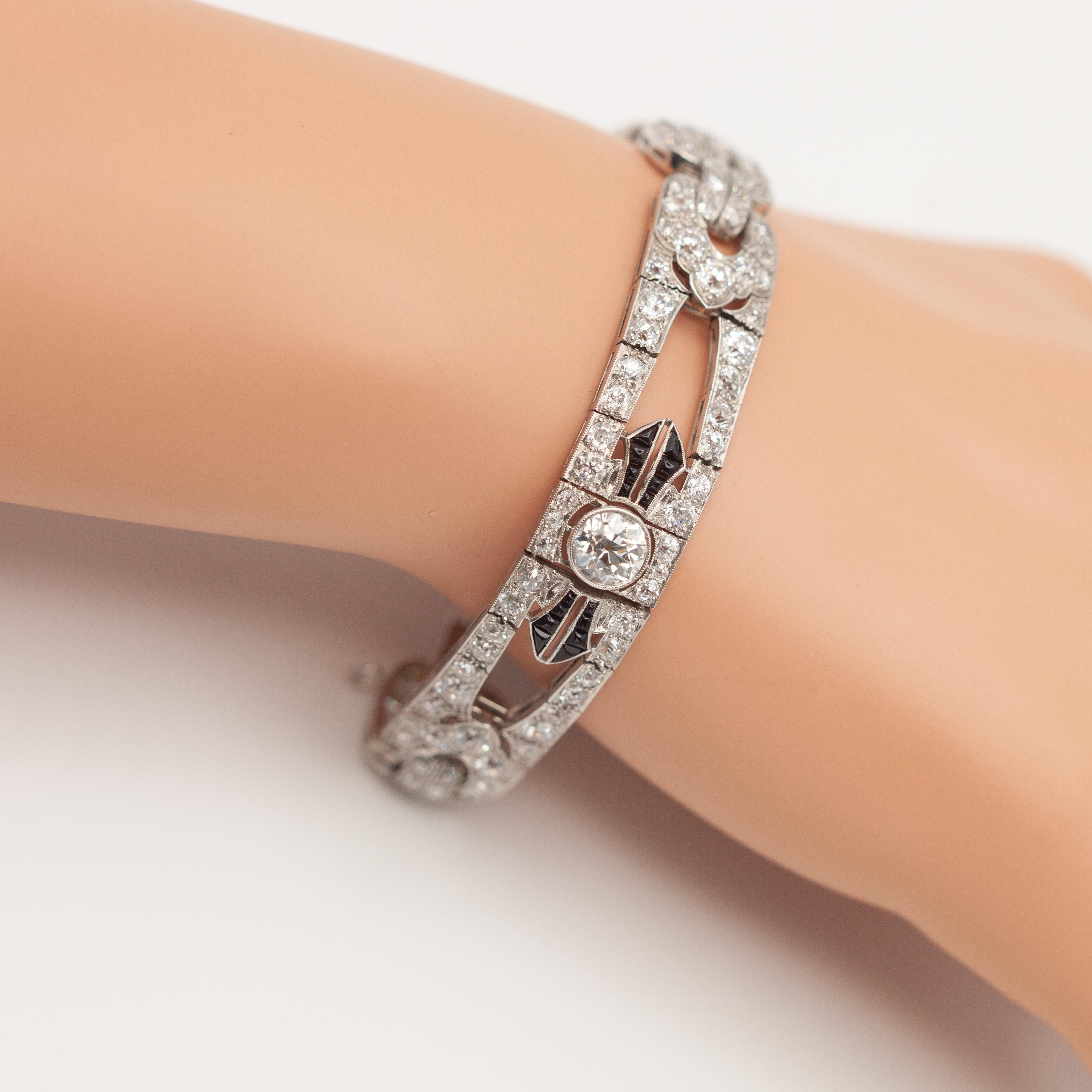 Impresionante pulsera Art Decó de diamantes en platino engastados con 148 diamantes talla europea antigua de aproximadamente 16,26 quilates de color H y claridad VS-SI y ónix talla cabujón, los 2 diamantes centrales más grandes de aproximadamente
