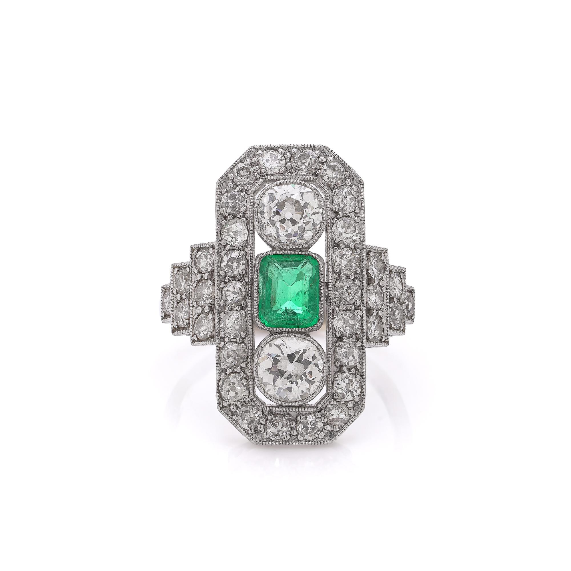 Bague exquise de style Art Deco, réalisée vers 1920 en or 18 carats et en platine, présentant un motif géométrique frappant, typique de l'époque. La bague est centrée sur une émeraude colombienne naturelle d'environ 0,50 carat, présentant une