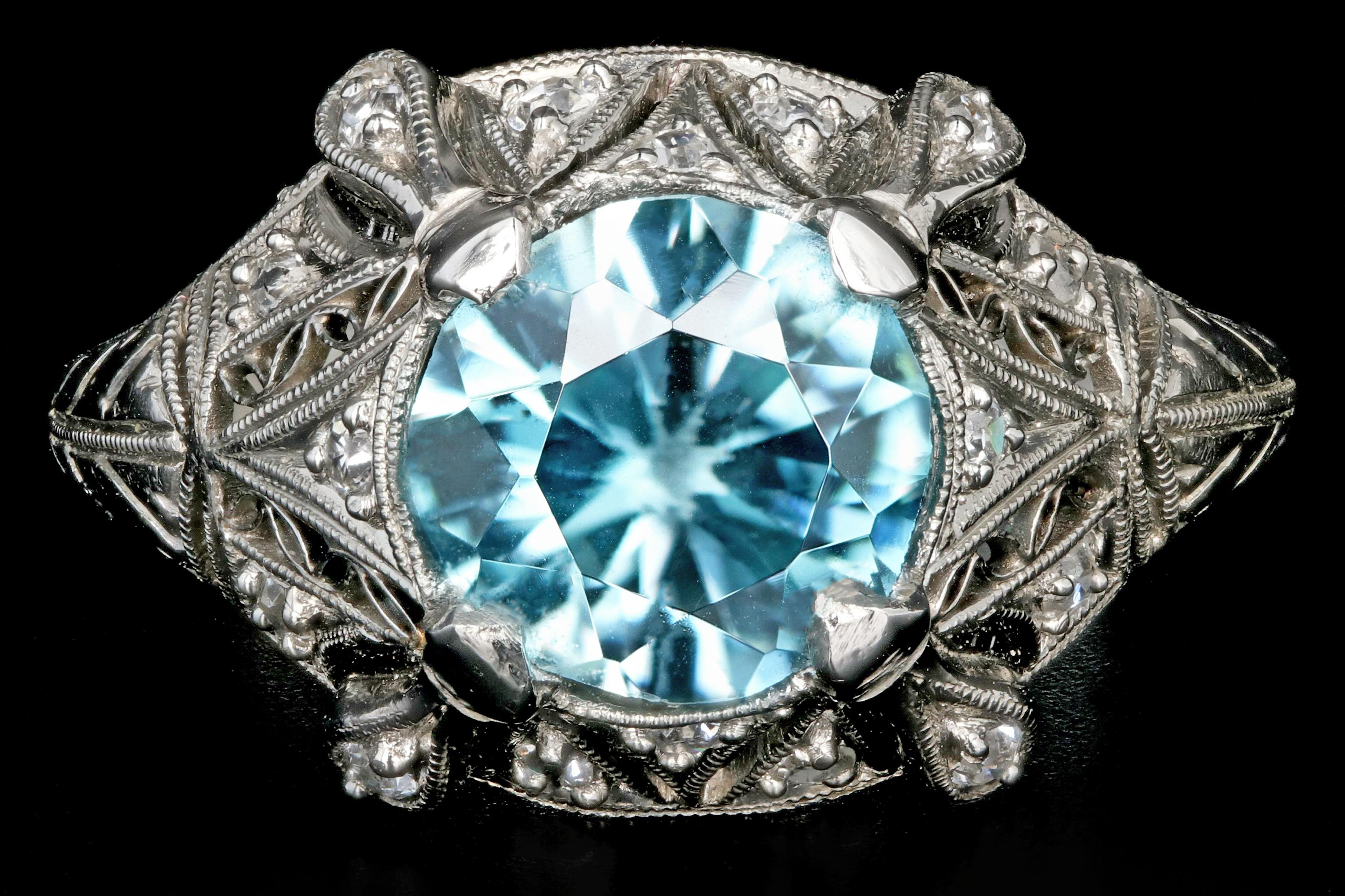 Era: Art Deco

Composition: Platinum

Primary Stone: Round Brilliant Cut

Carat Weight: 2.1CT Blue Zircon

Secondary Stone: Single cut diamonds

Carat Weight: Approximately .15ctw

Color: G/H

Clarity: Si1/2

Ring Weight: 4.9 grams

Ring Size: 5.5 