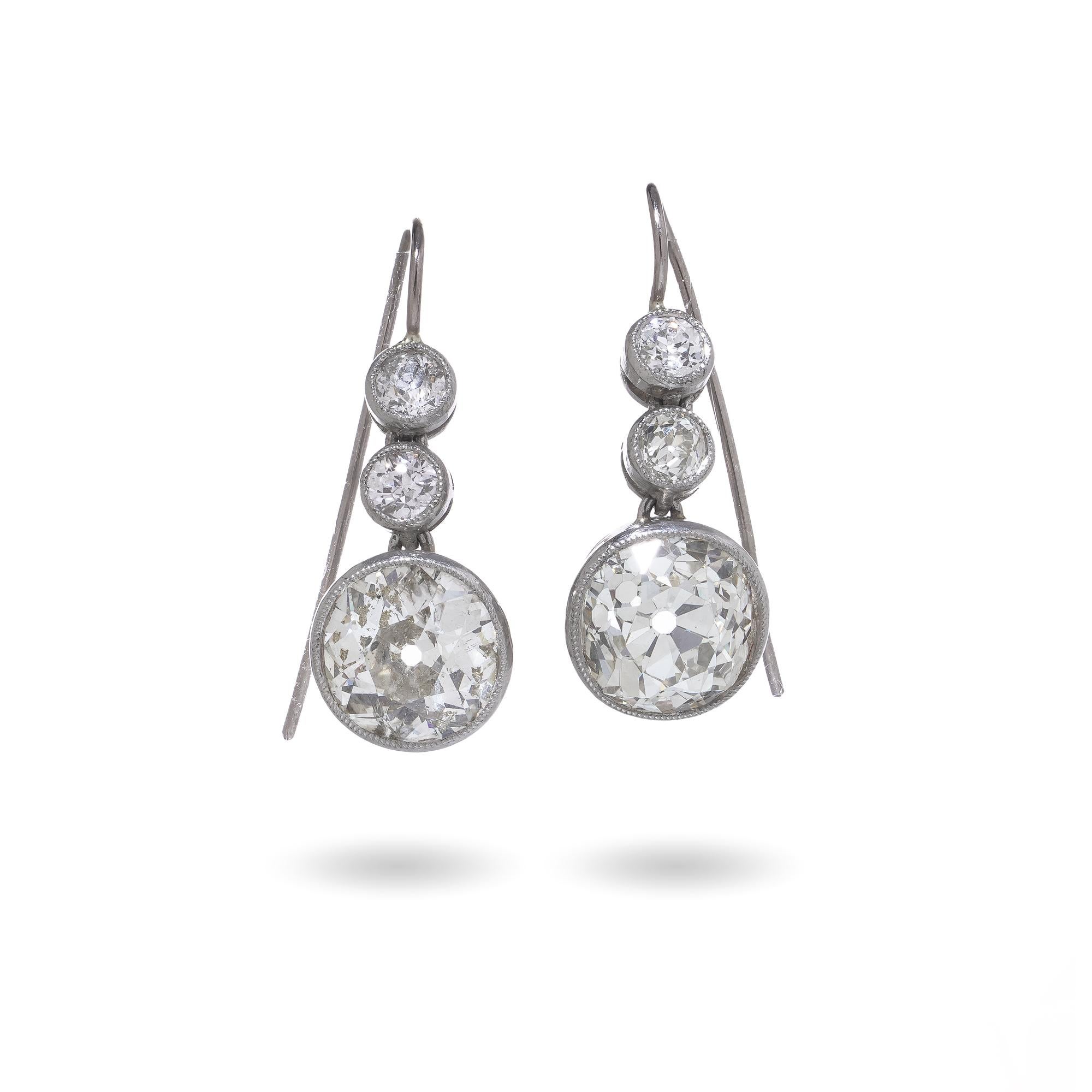 Ein Paar Art-Déco-Ohrringe aus Platin aus den 1920er Jahren, besetzt mit je drei Diamanten im Altschliff in abgestuften Fassungen. Bei den Hauptsteinen handelt es sich um große Steine im alten europäischen Schliff, die durch kleinere Akzentdiamanten