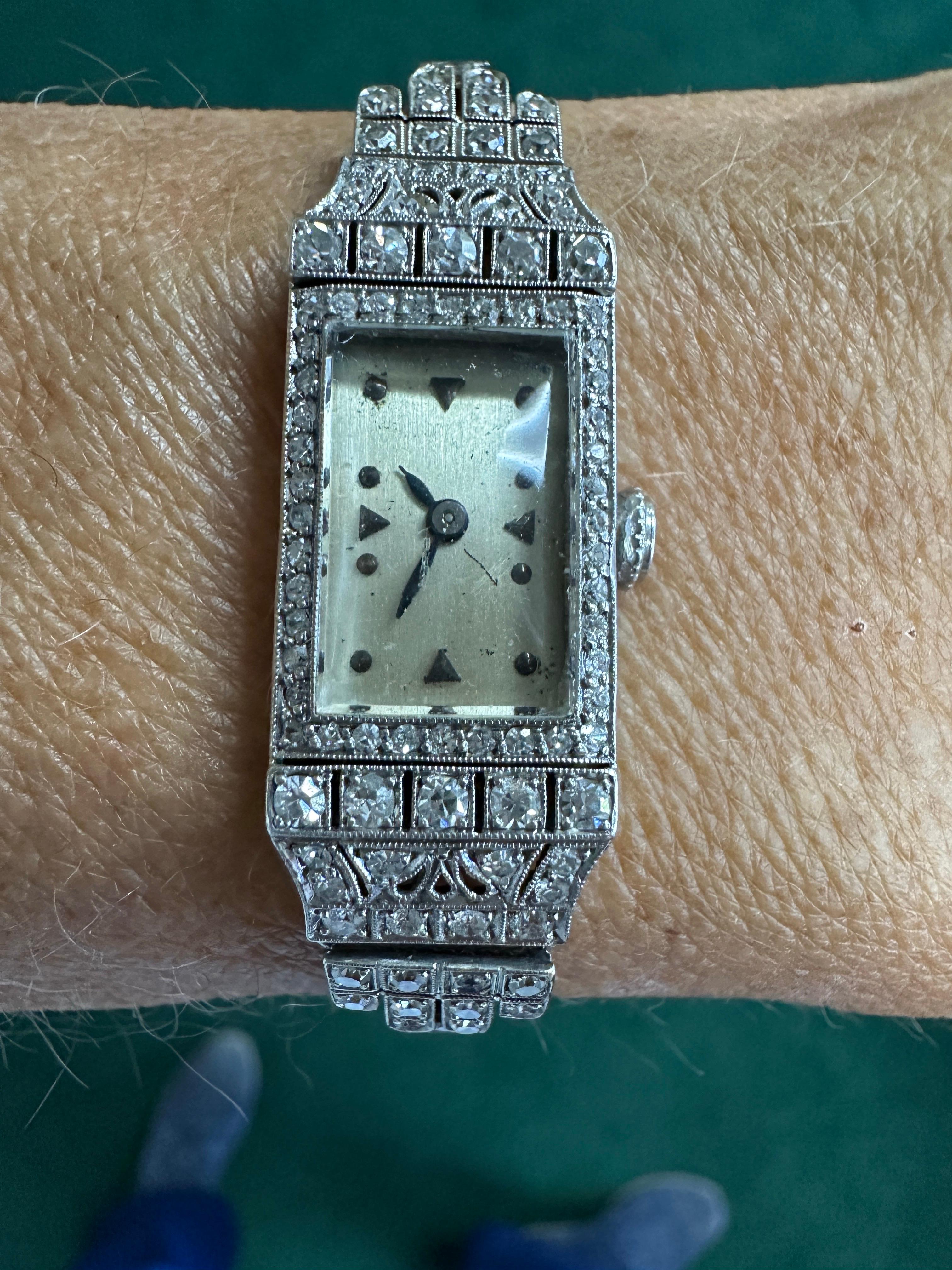 Cette exquise montre Art déco présente un total de 3,50 carats de diamants pavés de taille européenne, de pureté VS et de couleur F-G, méticuleusement sertis sur le bracelet et le boîtier. Fabriqué dans 25,29 grammes de platine, son boîtier gravé à