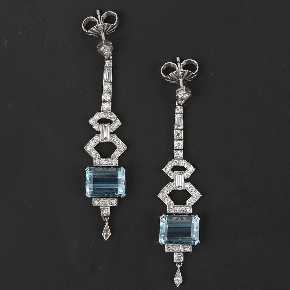 A striking pair of platinum aquamarine and diamond drop earrings. In typical Art Deco geometric style these earrings are made up of two 2.10 carat aquamarines with a combination of baguette, emerald and eight cut diamonds (estimated 1.30ct in total)