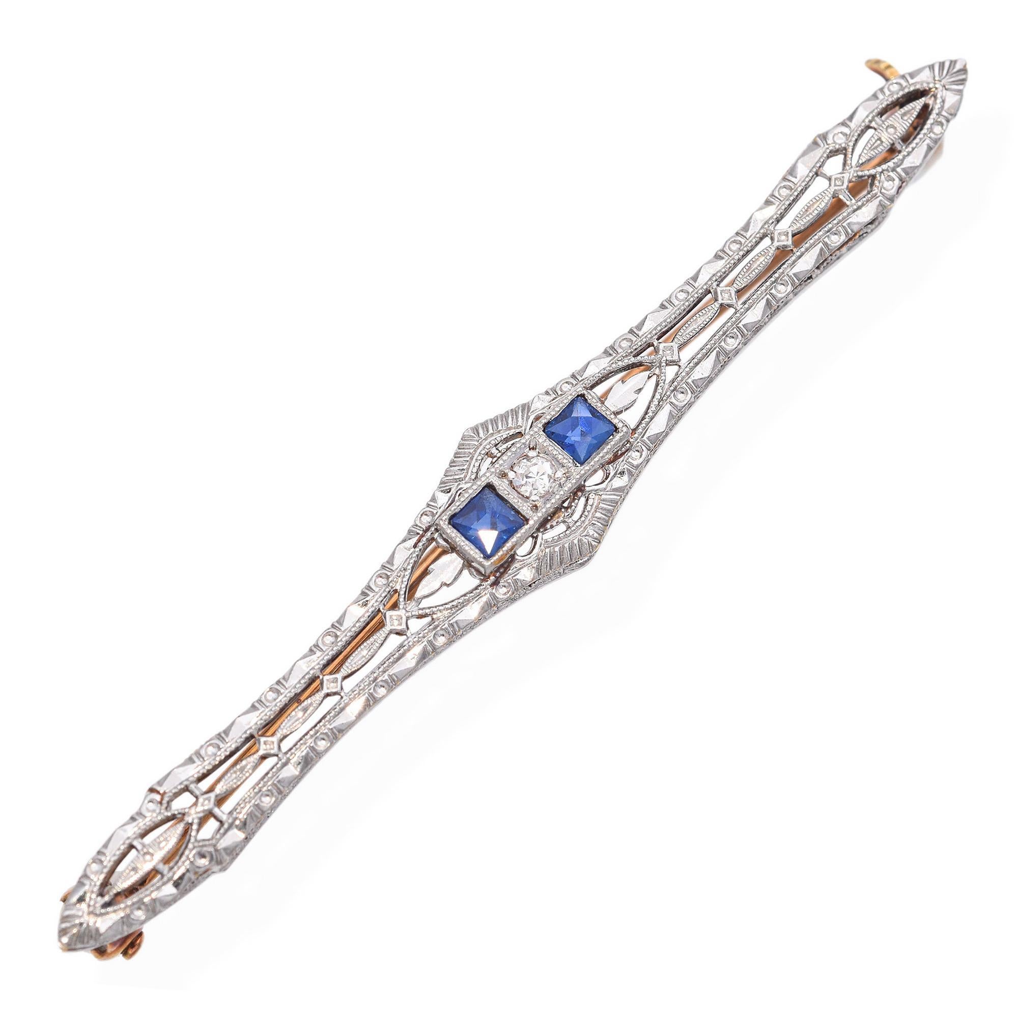 This Art Deco brooch features a delicate filigree design. Two vibrant sapphires flank a central white diamond, set in platinum with a 14k gold back.
Refined and exquisite.

Weight: 2.6 Grams
Stone: Sapphire, Diamond
Measurements: 45.5 x 1.5 x 1.5