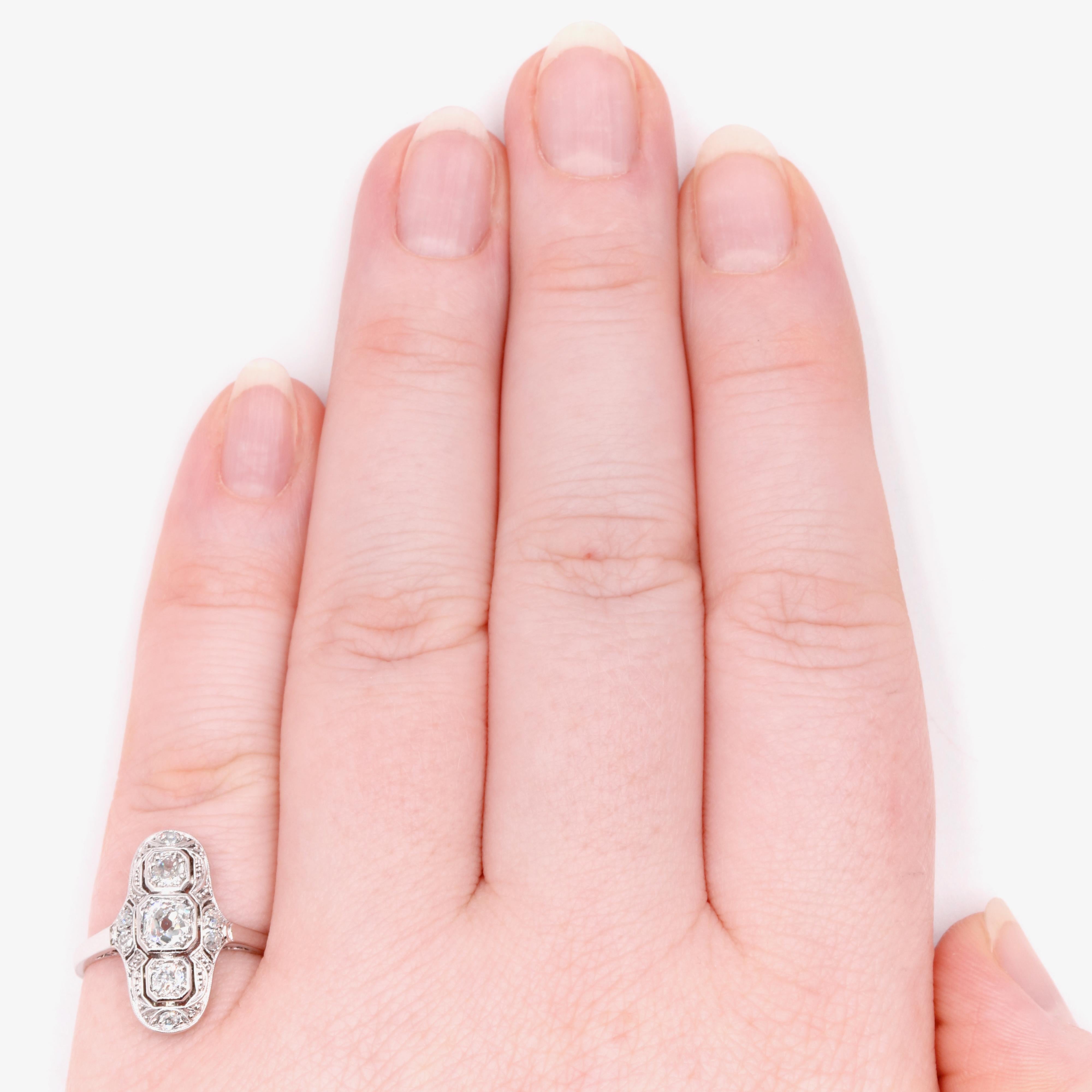 An Art Deco diamond, platinum?, and white gold? Ring, comprising one large old European cut diamond, two smaller old European cut diamonds, and six old single cut diamonds, set in platinum, to a 14 karat white gold band. 

This statuesque Art Deco