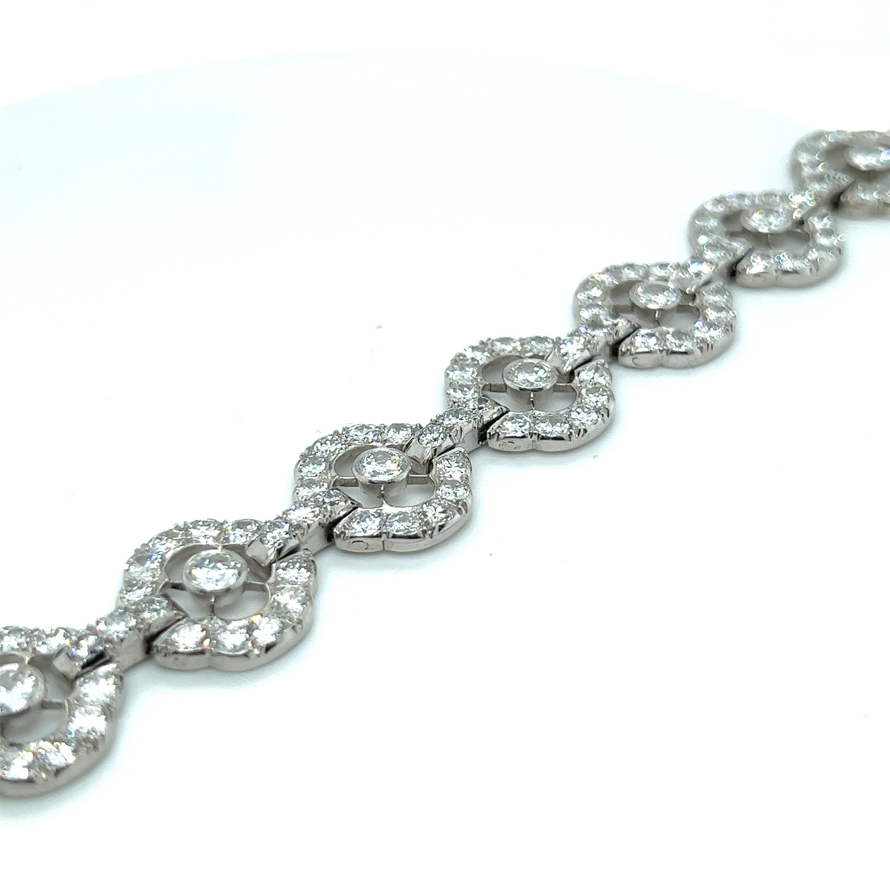 Elegant Art-Déco platinum and diamond bracelet. 

Delightful Art-Déco bracelet, designed as a series of open work, round floral motifs, each set with eleven circular-cut diamonds, joined by slightly arched diamond-set connecting links. The total