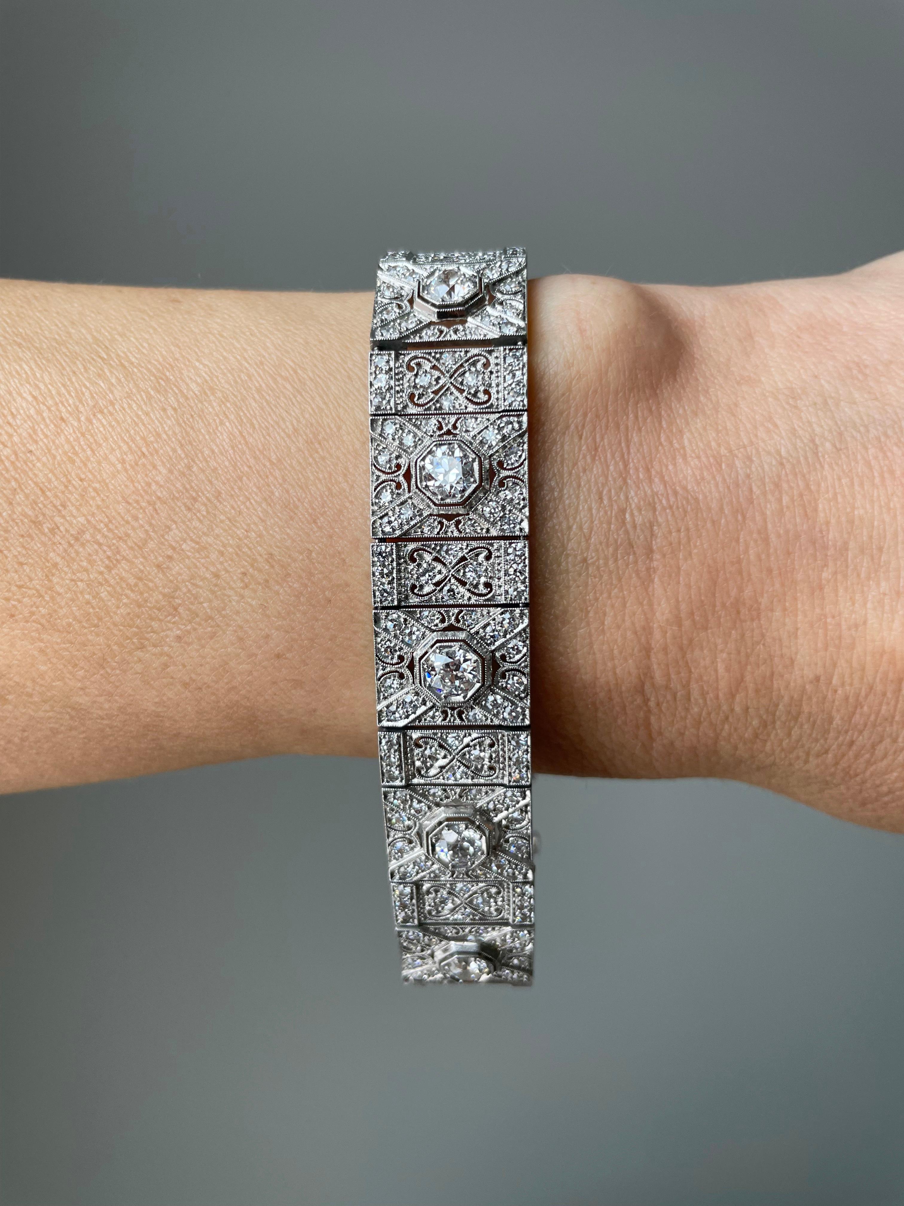 This dazzling Art Deco bracelet features a line of 11 bright-white European-cut diamonds, totaling 4.25 carats, presented in crisp, two-tiered octagonal settings, slightly raised above a rigorously detailed platinum bracelet. The bracelet glitters