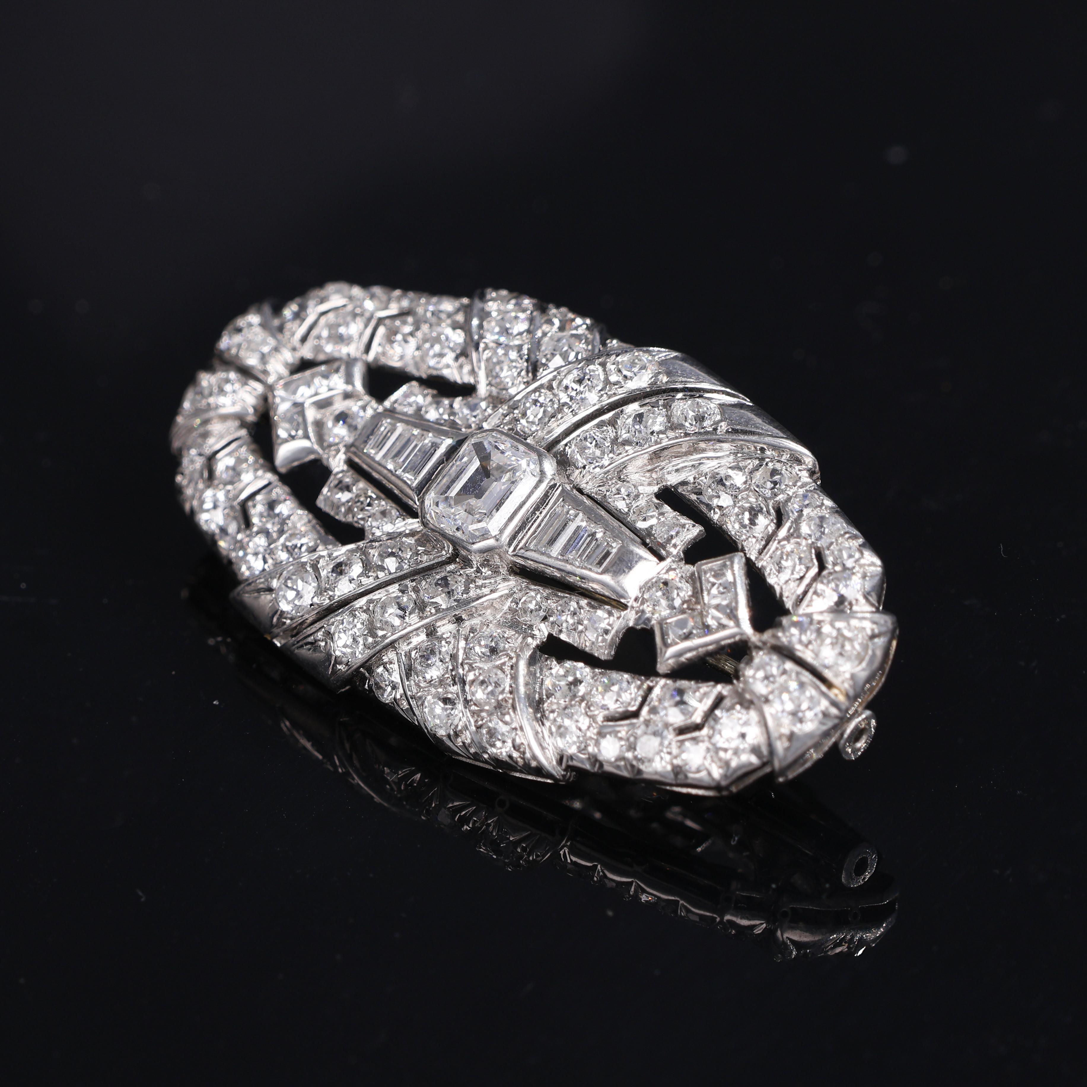 A striking Art Deco brooch from the 1930s, crafted in platinum and set with approximately 5.50 carats of natural white diamonds. The composition features baguette-cut diamonds arranged in a geometric design, characteristic of the era, with a central