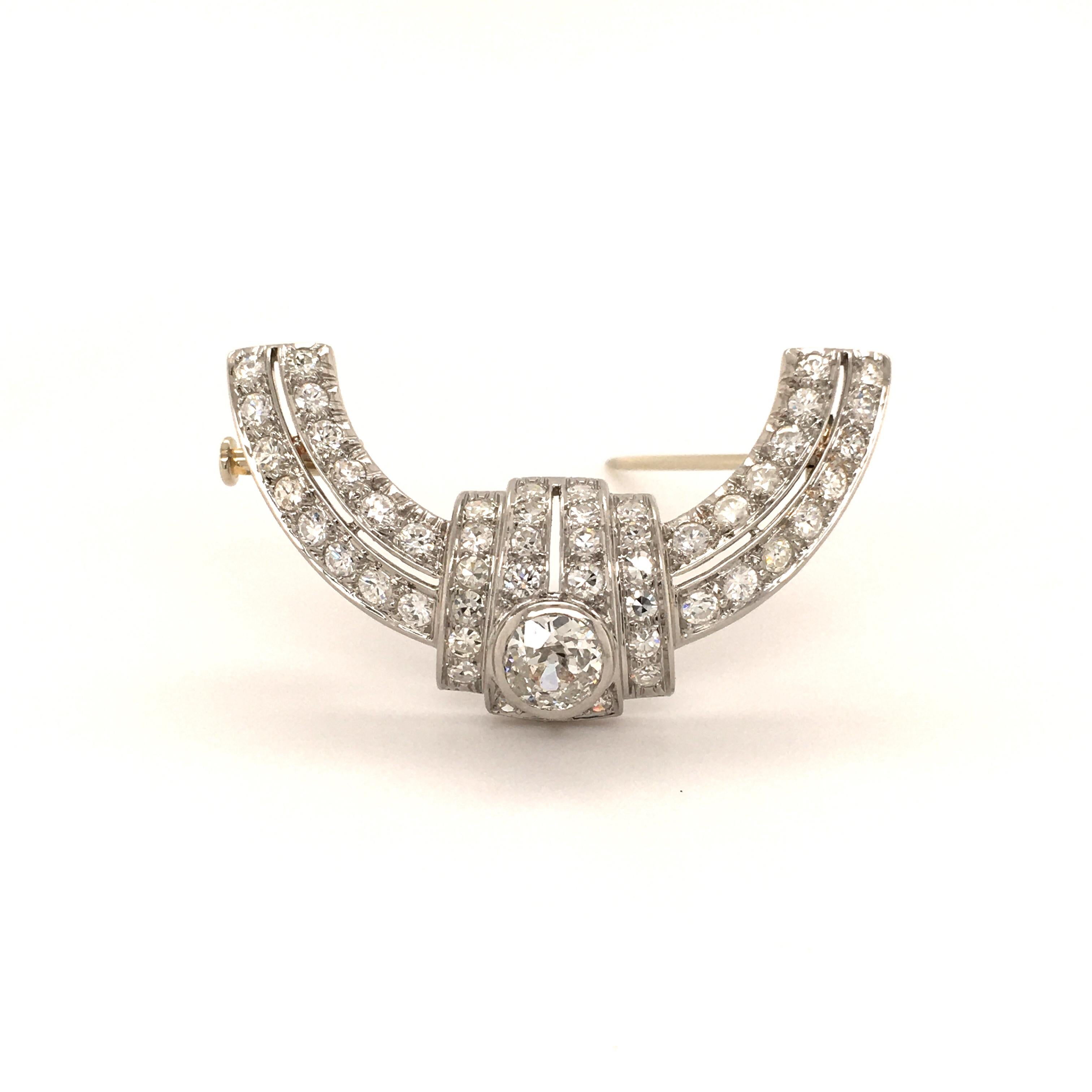 This platinum and diamond Art Deco brooch is set with one old cut diamond of 0.74 carats, F/G color and i1 clarity. Fine openwork setting in platinum 950 with 50 single cut diamonds of G/H color and vs/si clarity, total weight approximately 2.00