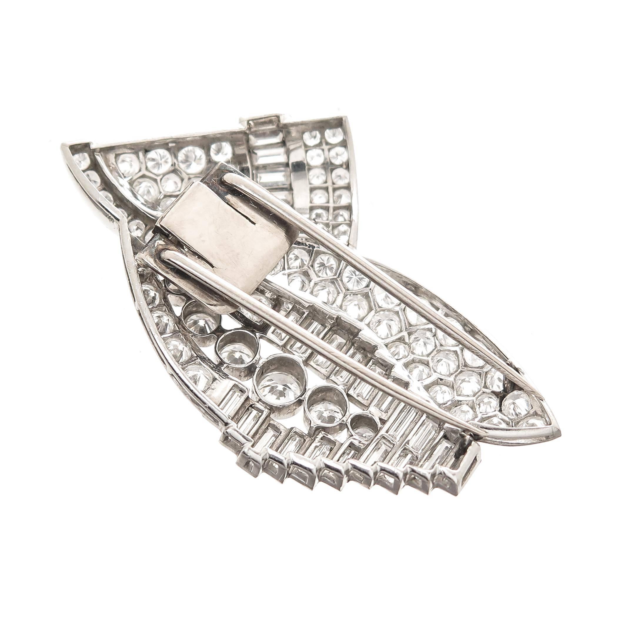 Circa 1930s Platinum Dress Clips, in a very Art Deco form, measuring 2 1/8 inches in length and 1 1/8 inch wide. The clips are set with Round Brilliant cut and Baguette Diamonds totaling 15 Carats and Grading as G in color and VS in Clarity. Both