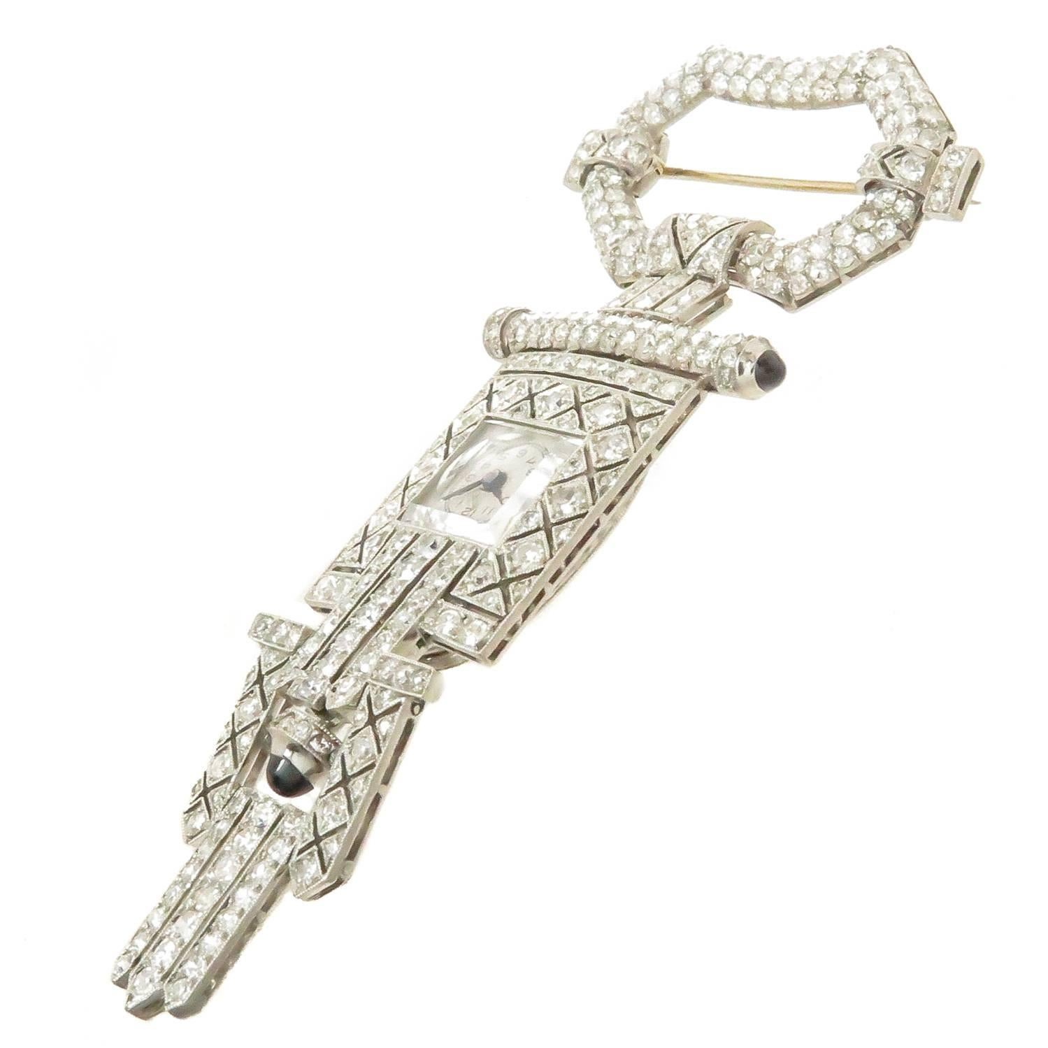 Circa 1930 High Art Deco Style Platinum Lapel Watch. Measuring 3 1/4 inches in length and 1 1/2 inch wide. Each section is flexible and gives this piece great movement, set with single cut Diamonds totaling 4 Carats and further set with Cabochon