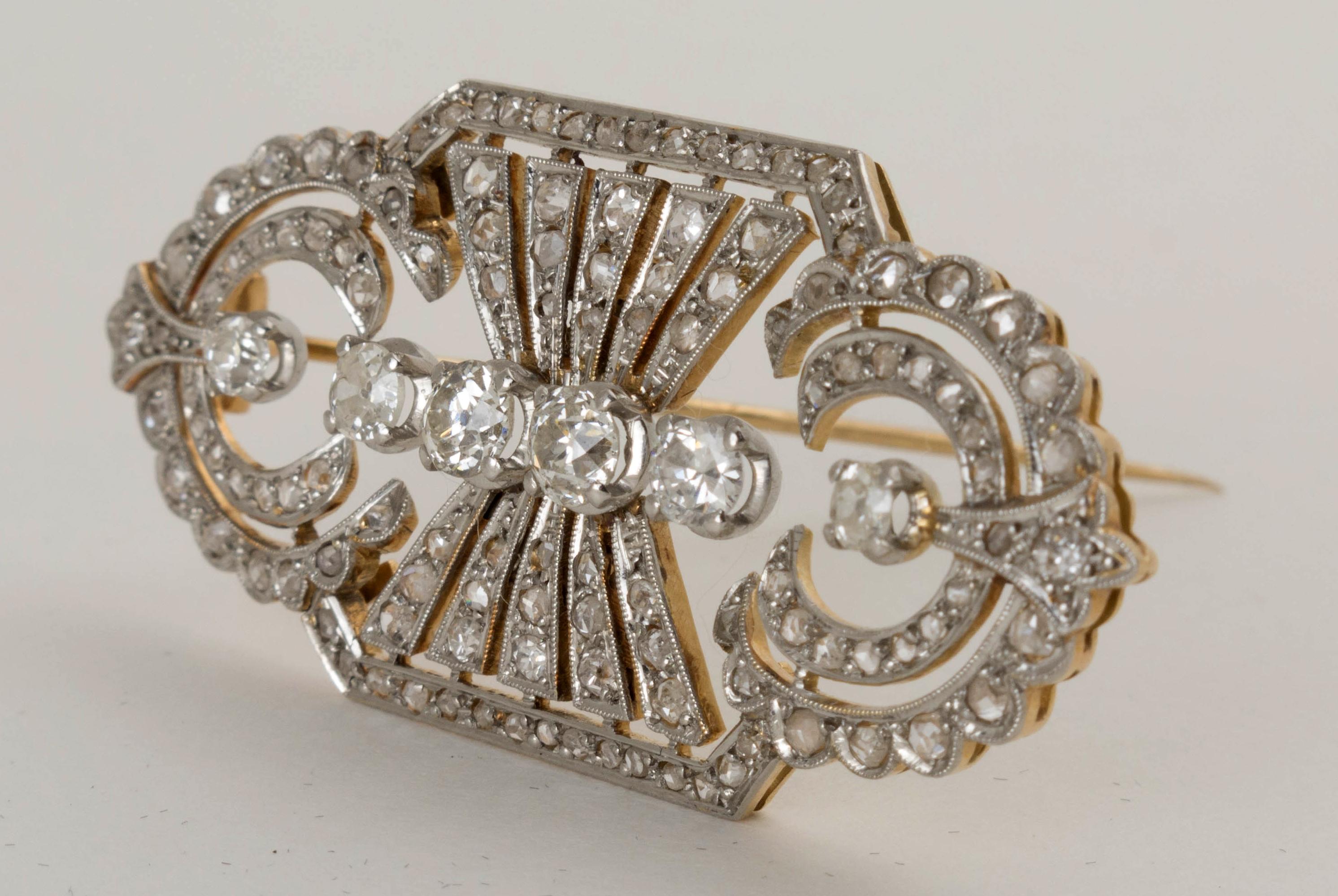 An absolutely stunning English Art Deco diamond brooch set in 18k yellow gold and topped with platinum, circa 1930's.

The brooch of classic Art Deco design with an overall rectangular shape, the shorter ends rounded, and formed as concentric