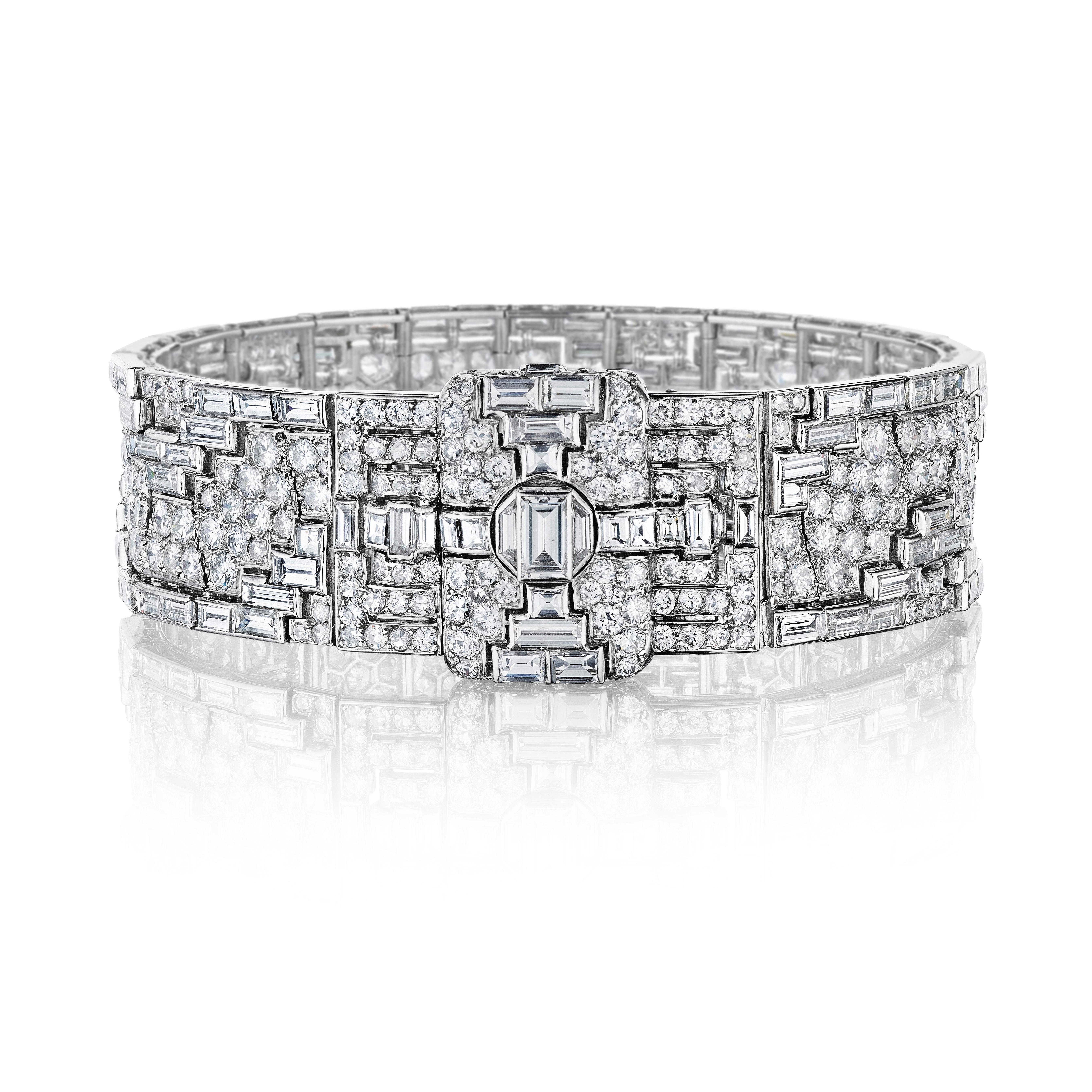 A flexible strap bracelet of geometric design with a repeating stepped pattern set with baguette diamonds within a ground of pavé-set diamonds, completed by a rectangular clasp of similar design; mounted in platinum
• 427 round and baguette