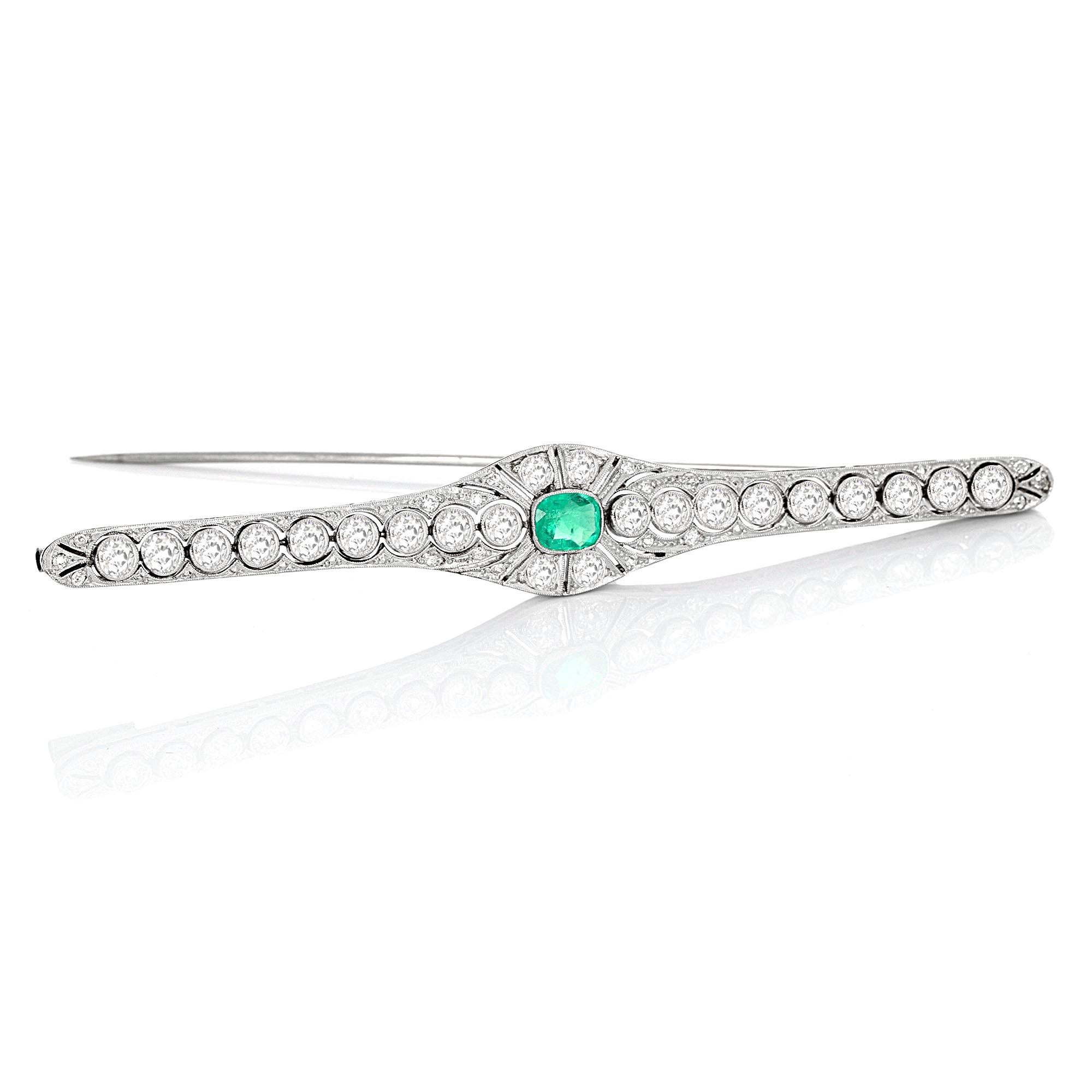 Art Deco platinum antique emerald and diamond bar brooch. The center stone is a cushion cut emerald. There is an estimated 4.25 carat total weight of a white, eye clean, old European cut diamonds.

The brooch measures 3.5 inches x 0.5 inches and