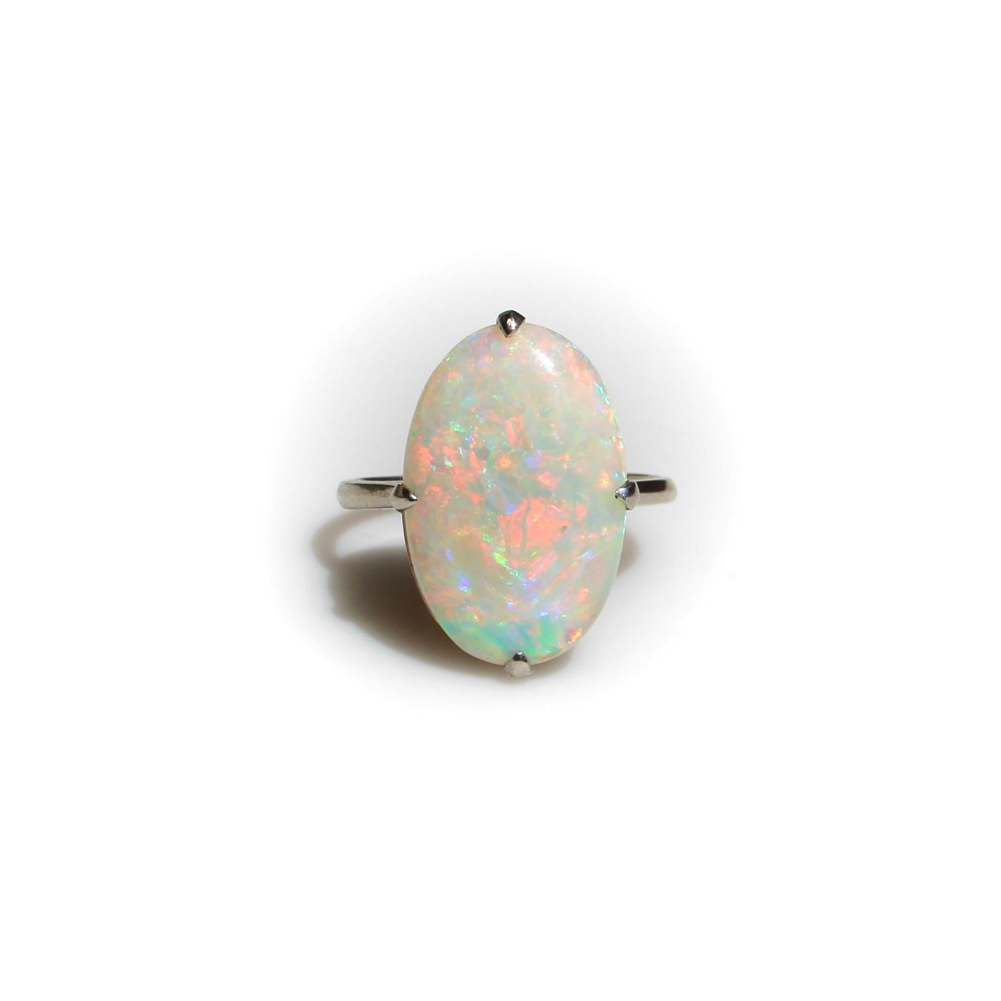 The standout features of this Art Deco ring are the beautiful Australian opal cabochon and the simplistic yet refined handmade platinum mount. The opal has intense color play in every color of the rainbow—a myriad of oranges, pinks, greens, blues,