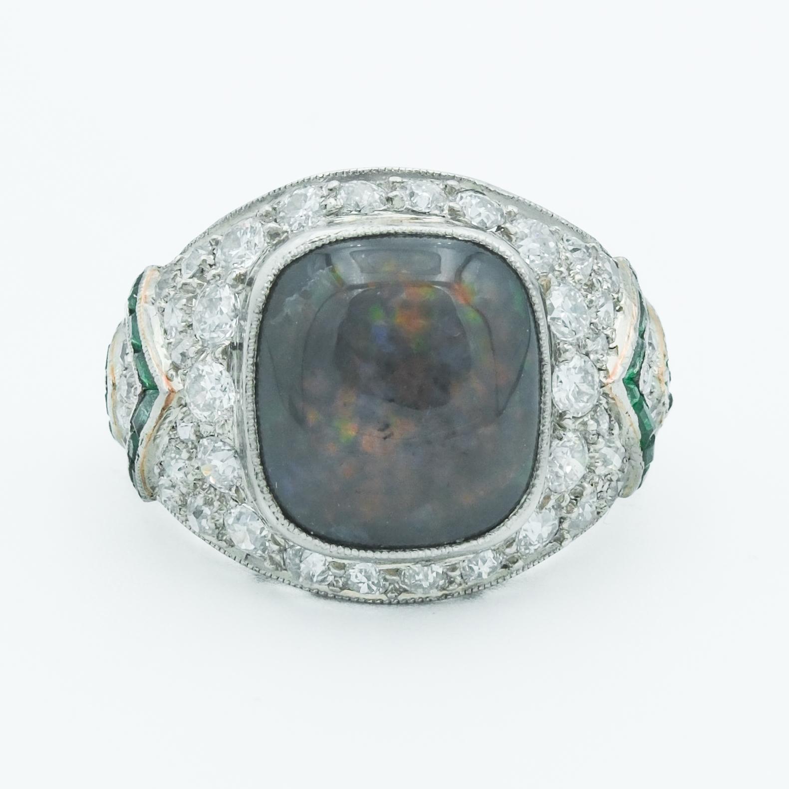 This exquisite platinum Art Deco ring features a stunning 4-carat black opal, which takes center stage as a cabochon cut, exhibiting a mesmerizing play of color, a characteristic for which fine opals are renowned. The opal is complimented by