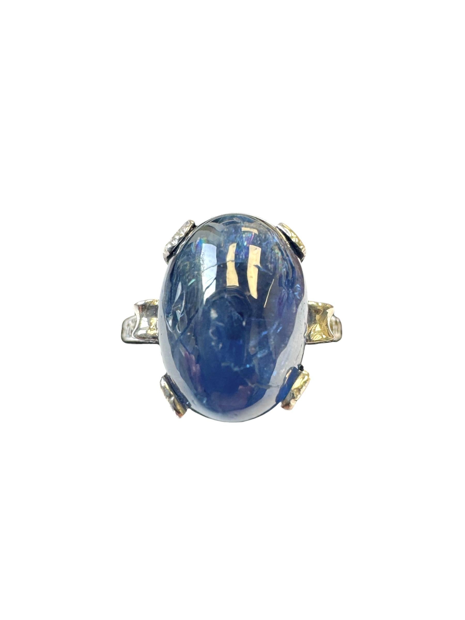 A striking example of Art Deco craftsmanship, this vintage ring features a mesmerizing 8.70-carat cabochon-cut sapphire with deep blue hues and natural inclusions, set in a finely hand-engraved platinum mounting. Four old European-cut diamond